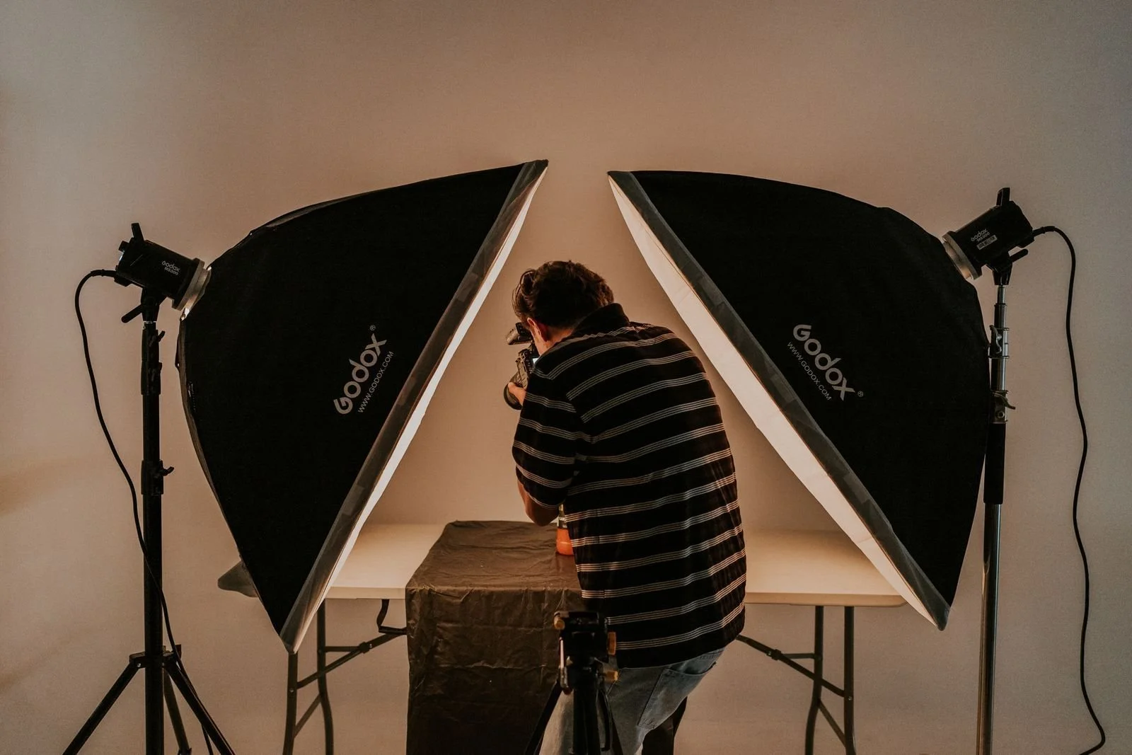 Photographer working with a softbox in a portrait studio, the classic softbox vs umbrella comparison setup
