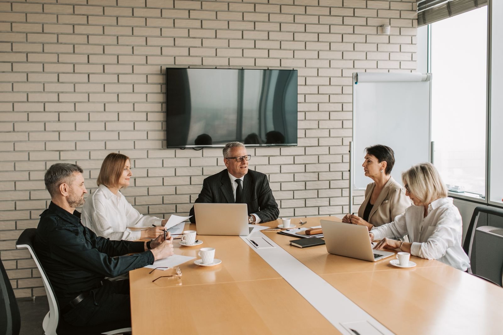 Corporate executives in a boardroom meeting covered by experienced business event photography