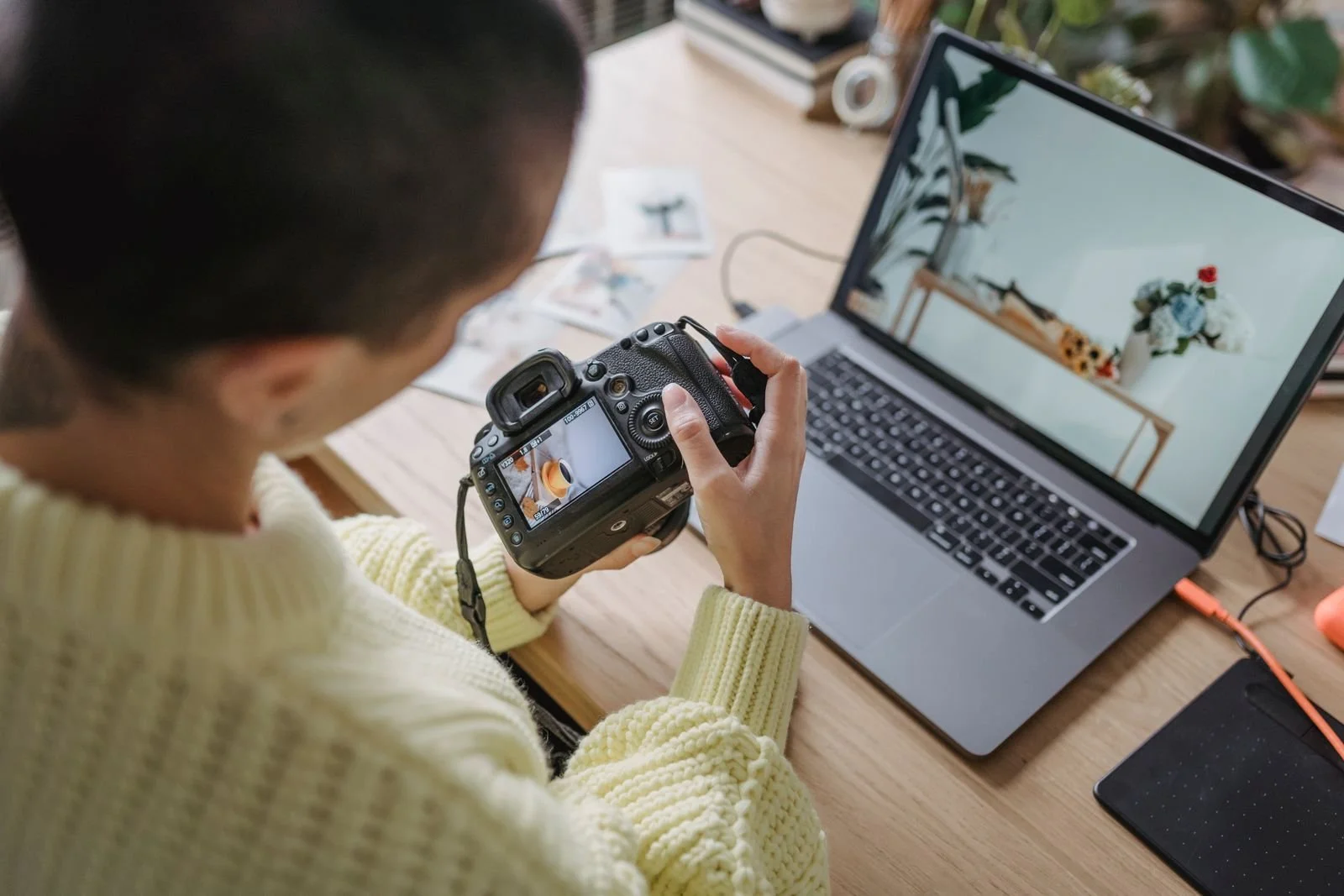 Photographer reviewing camera files on a laptop during the ingest stage of a photography backup workflow.