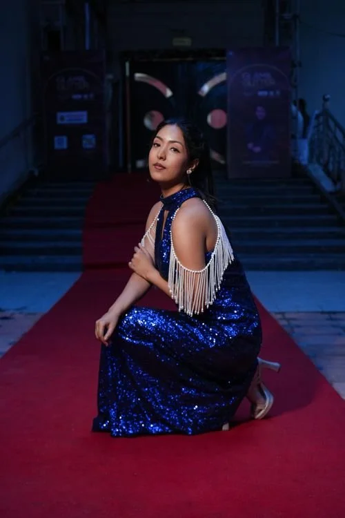 Woman in elegant gown posing on a red carpet at a Los Angeles premiere