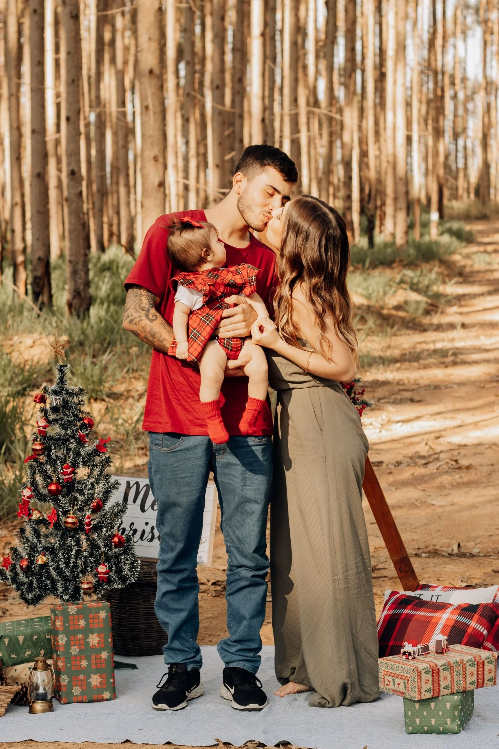 Family standing on a blanket with Christmas decorations in a park during an outdoor holiday mini session portrait shoot