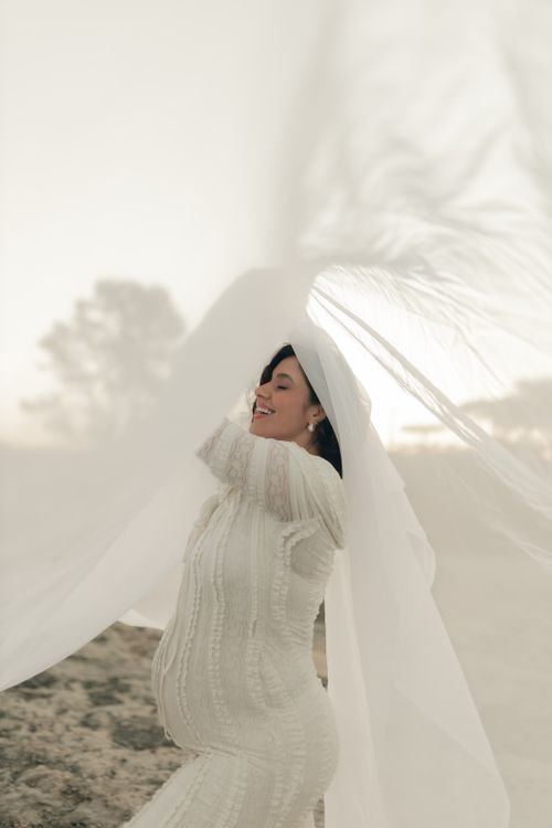 Pregnant woman in a flowing dress at golden hour in the Los Angeles hills, outdoor maternity photoshoot