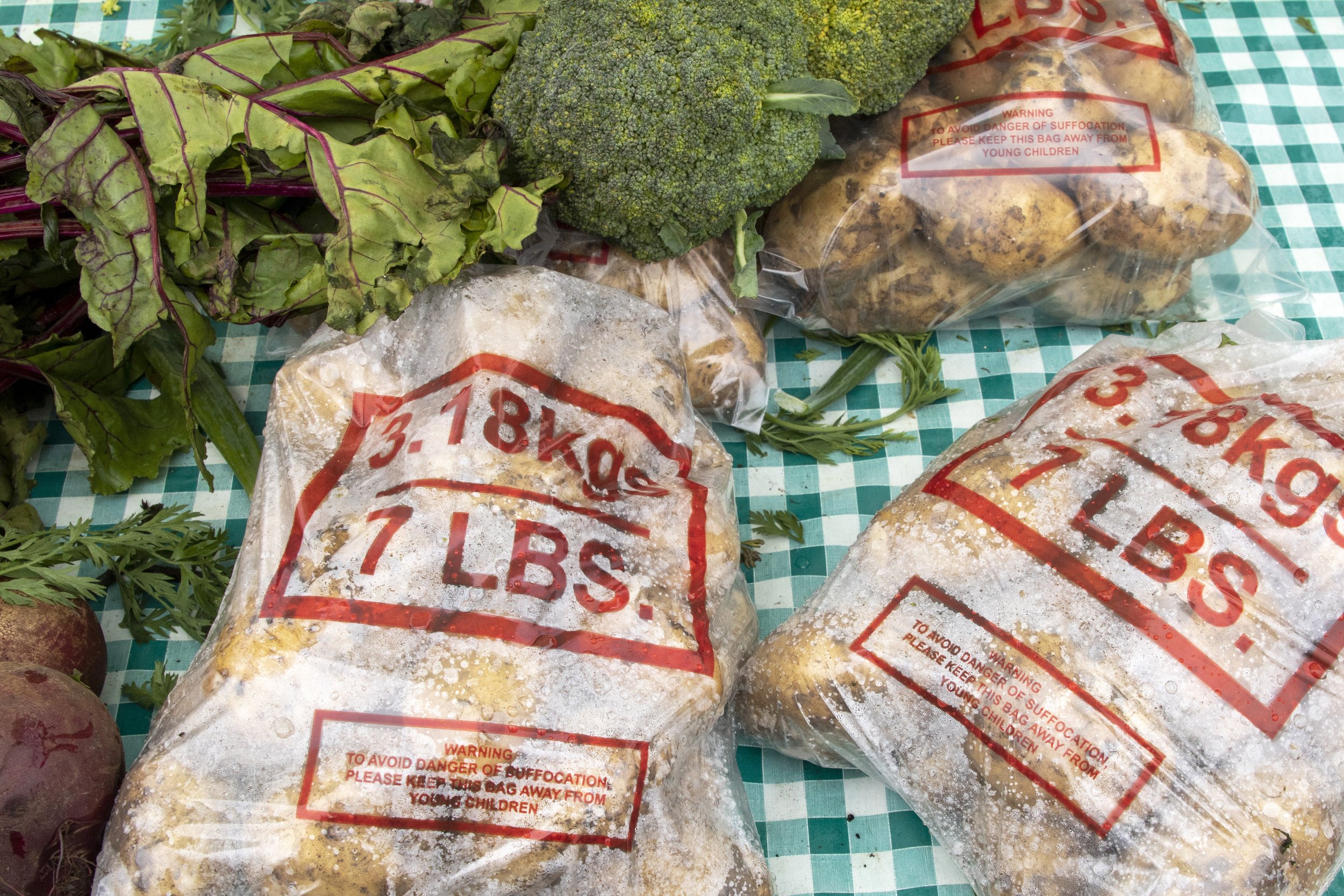 I was down here this morning at 7 o’clock. I’ve been coming to this market for 15 or 16 years. When I started out I could have that whole table full of bags of spuds and it all sold by 12 o’clock. Now, other markets sell them so cheap, 49 cents. But,