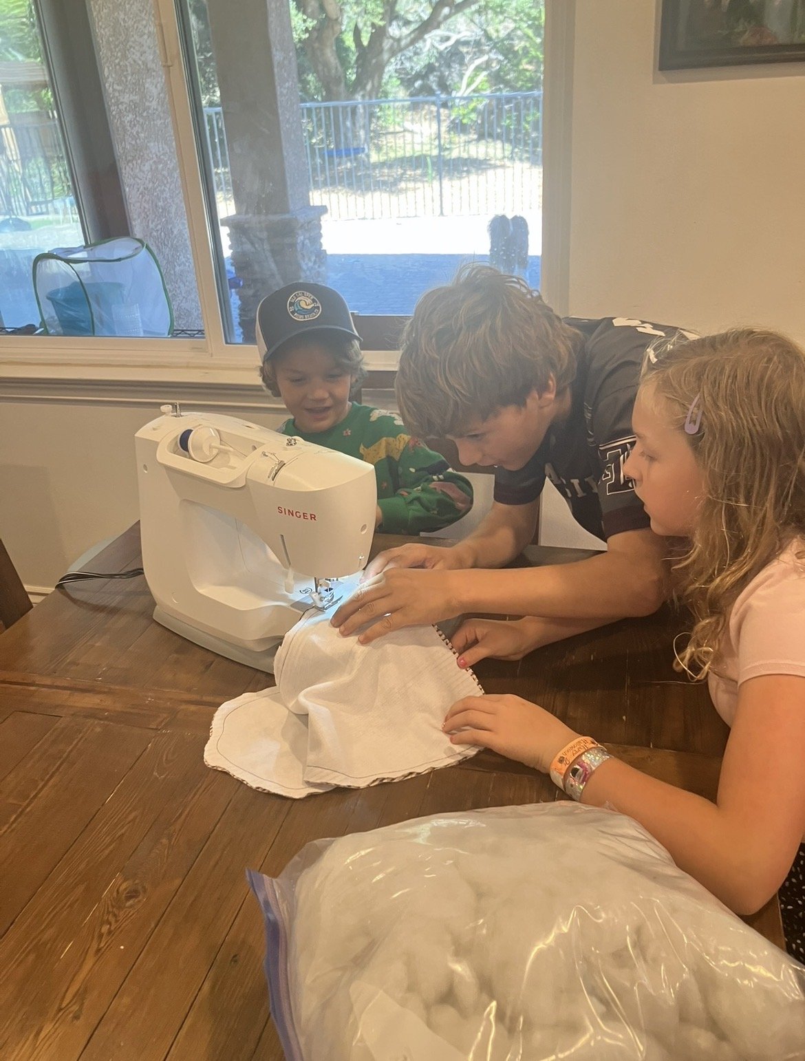 Evie helping younger children at the sewing machine