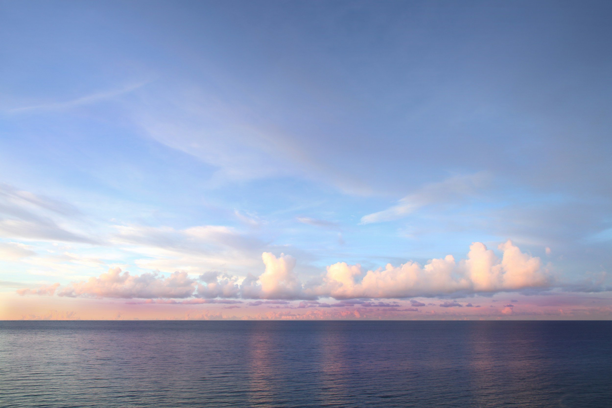 Calm ocean horizon at sunrise symbolising perspective and long-term thinking.