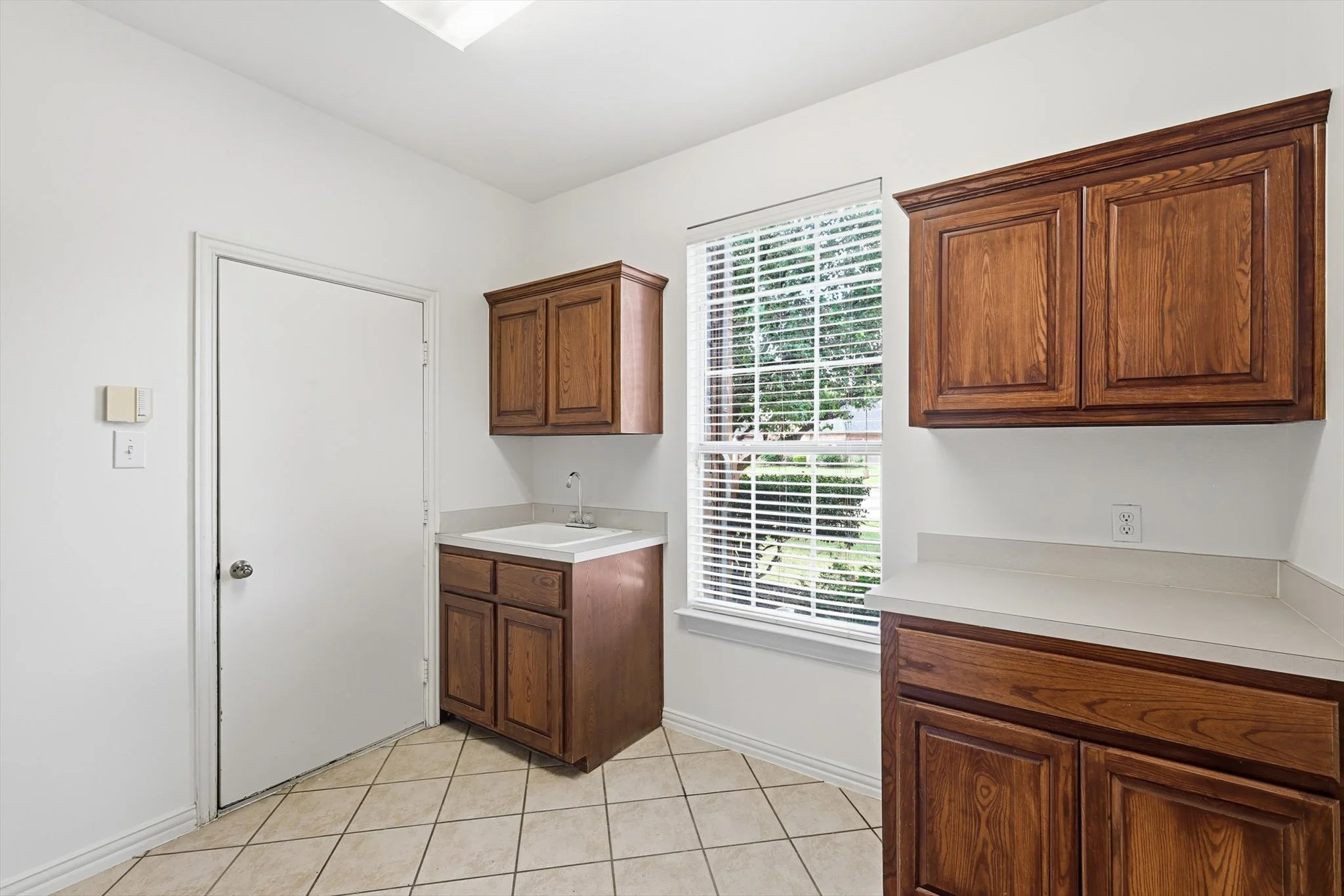 Oversized laundry room with sink, cabinets and counters