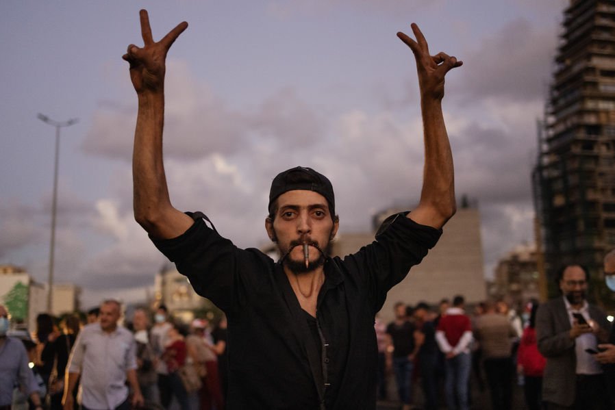  During a demonstration in Beirut, Lebanon, a man shows the peace sign while carrying a bullet. 