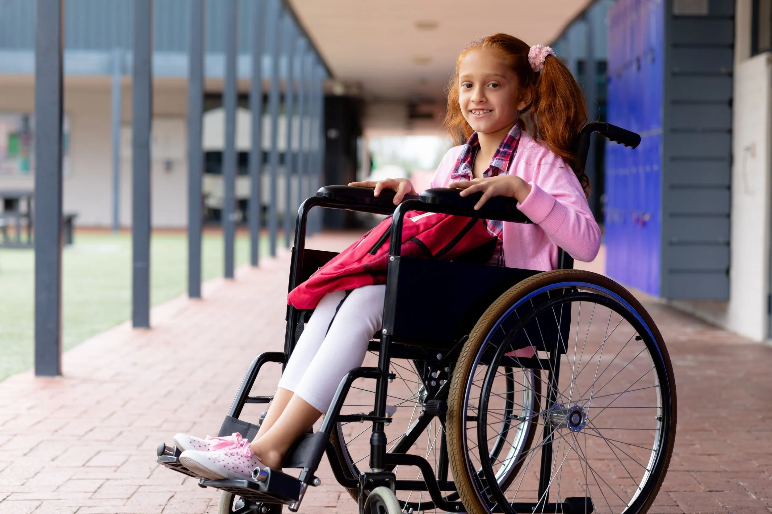 portrait-happy-biracial-schoolgirl-wheelchair-smiling-school-corridor.jpg