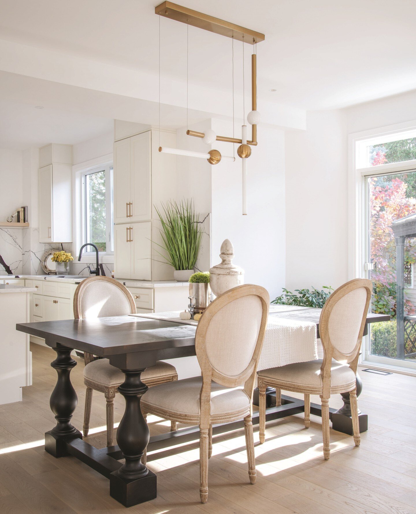 The dining table is close to the kitchen in this open concept remodelled home. Design details abound including the simple but impactful light fixtures. Ready for the dinner parties!⁠
⁠
Photo: Gordon King⁠
Design and Renovation: Terzetto Homes @terzet