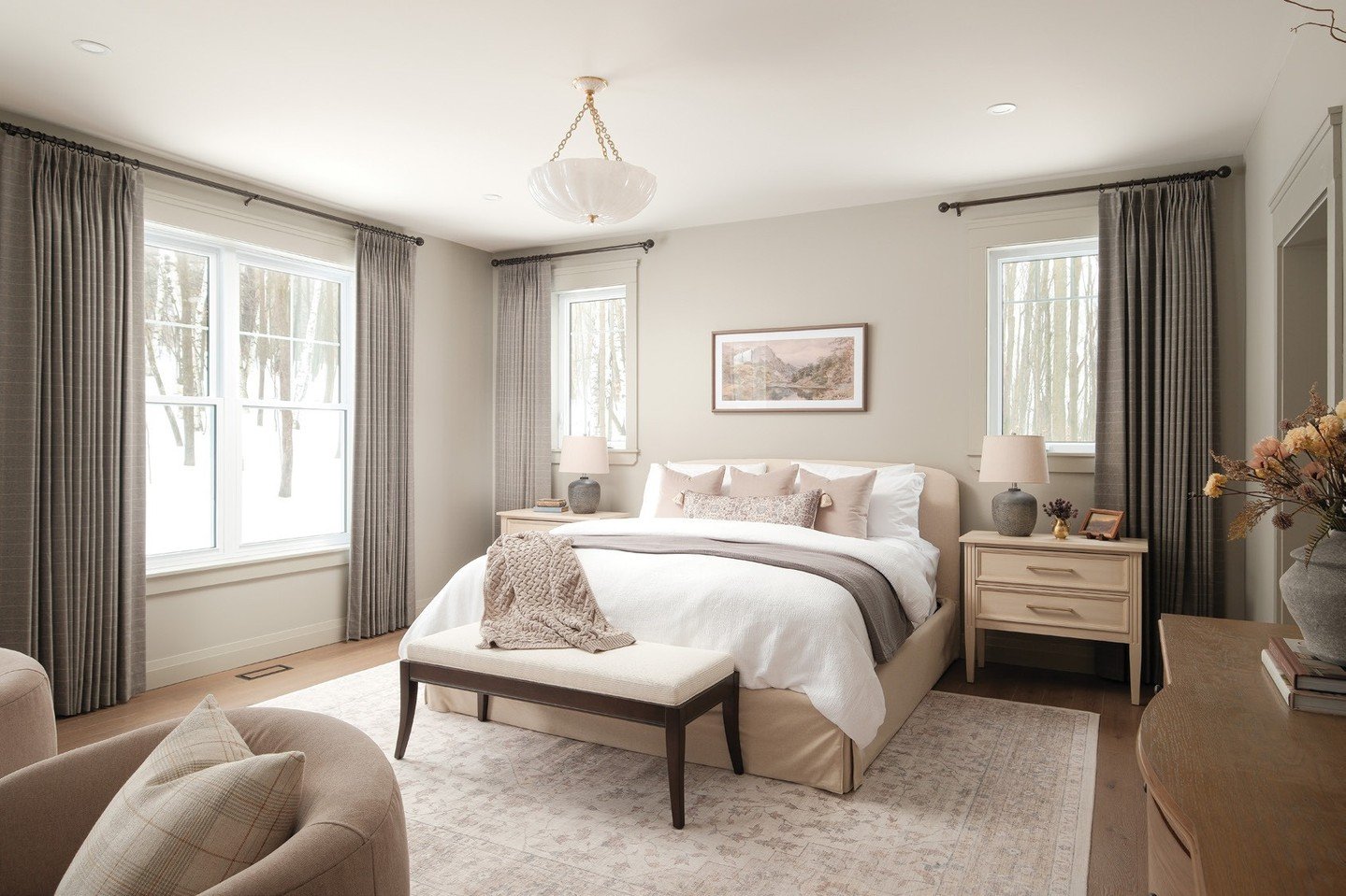 Guests who stay at this lovely home in Grafton, near Cobourg certainly enjoy their stay. They can begin and end each day in this peaceful primary bedroom.  The warm tones, the luxurious layered bedding and the serene view all add to their restful sle