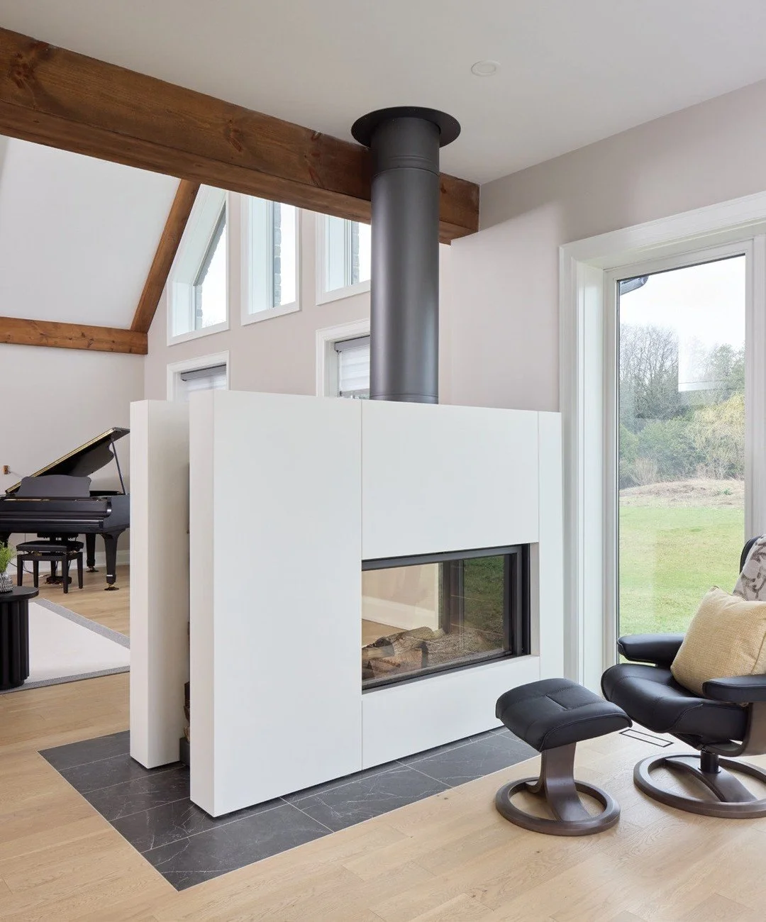 The double-sided fireplace became a defining feature of the great room, separating the main living area from a more intimate reading and gathering space, bringing warmth, ambience and visual connection throughout. The great room is flooded with natur