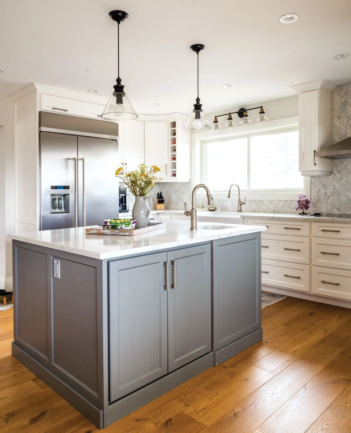 Rustic charm and modern style complement one another in this renovated farmhouse. The kitchen is framed by large windows to grant views of the surrounding acreage and welcome natural light. A unique feature is a secondary island close to the kitchen 