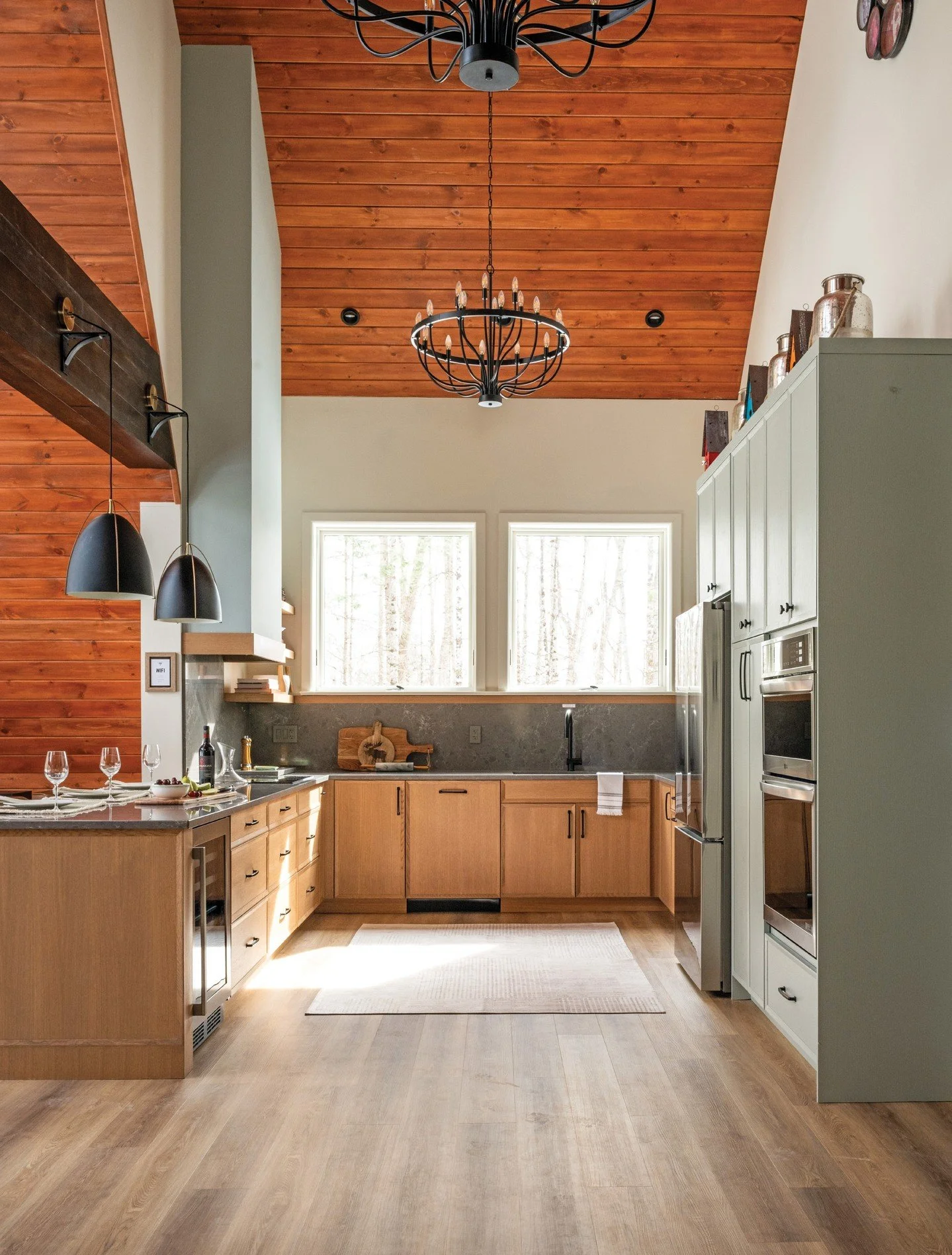 In the kitchen of this A-frame home, many small details shine. Slate grey quartz countertops echo the colour and strength of the Canadian Shield that anchors the home. The modern Shaker-style cabinetry features a rustic wood grain and tranquil hues c