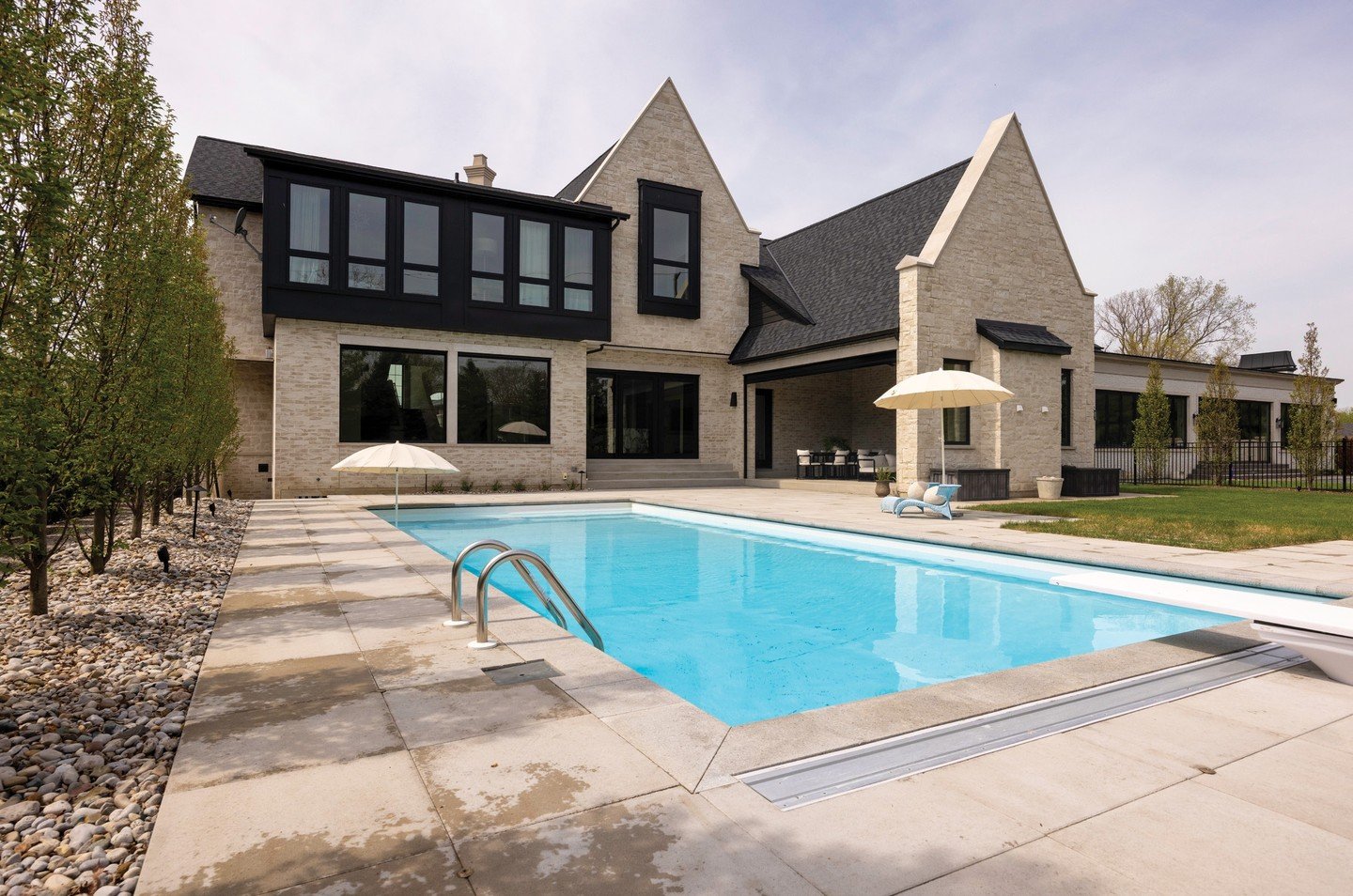 The Tudor-inspired exterior at this stunning LaSalle home combines steep rooflines, stone detailing and bold black accents, resulting in a look that is both timeless and modern. The backyard oasis offers plenty of space to entertain, with a streamlin