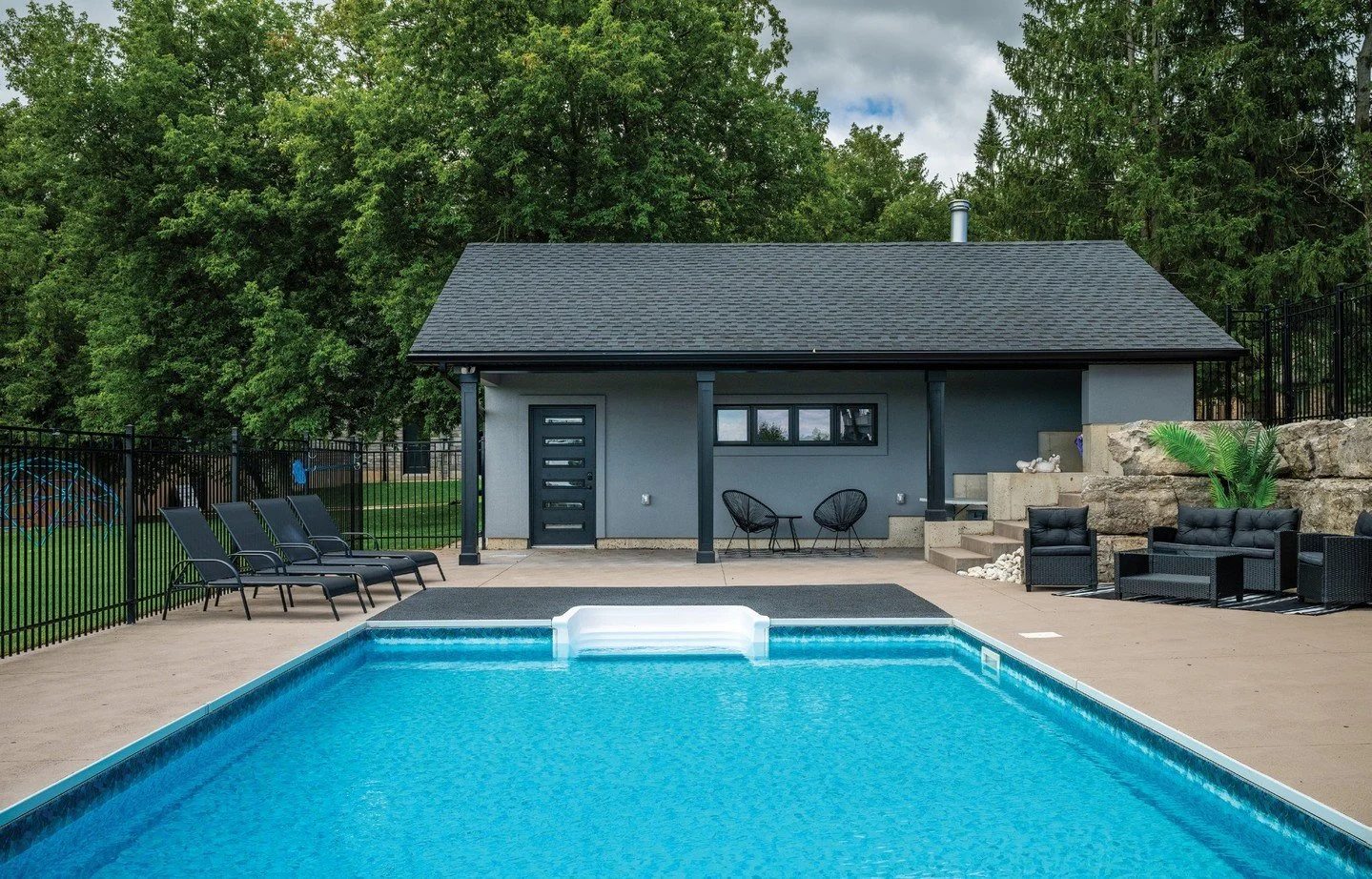 Featured on the cover of the Summer issue, here is a better look at the backyard oasis. The home&rsquo;s rear elevation showcases its thoughtful design and the deck surrounding the main level provides both dining and covered seating areas with views 