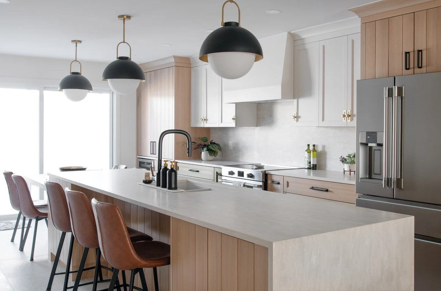 To ensure clean sight-lines and clutter-free countertops, a grand pantry was designed for this home appliances are kept and kitchenware hidden. The warm-white range hood and adjacent cabinets complement the Barcelona-stained wood in this beautiful Ro