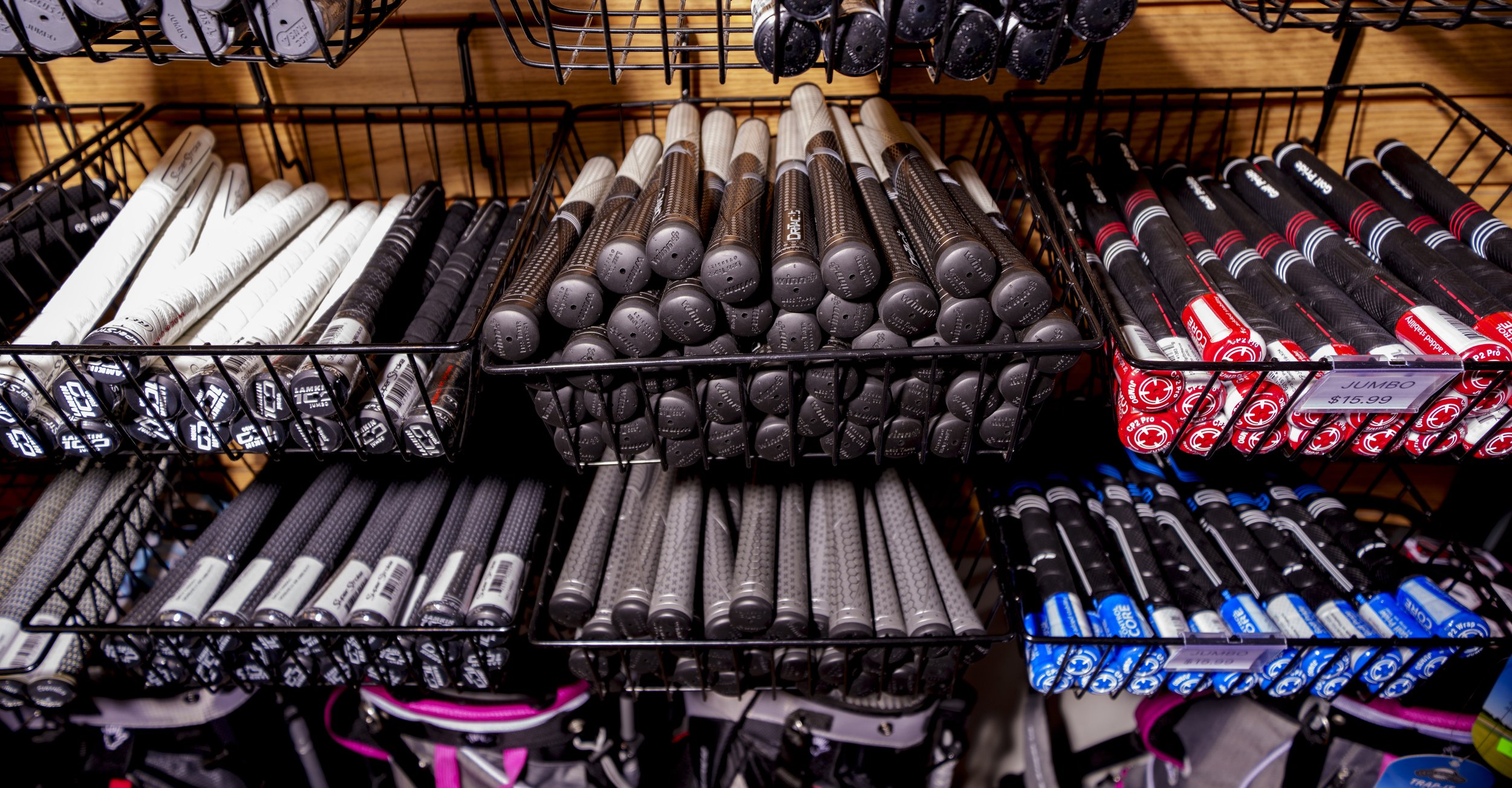 Display of golf club grips arranged on shelves in a store.