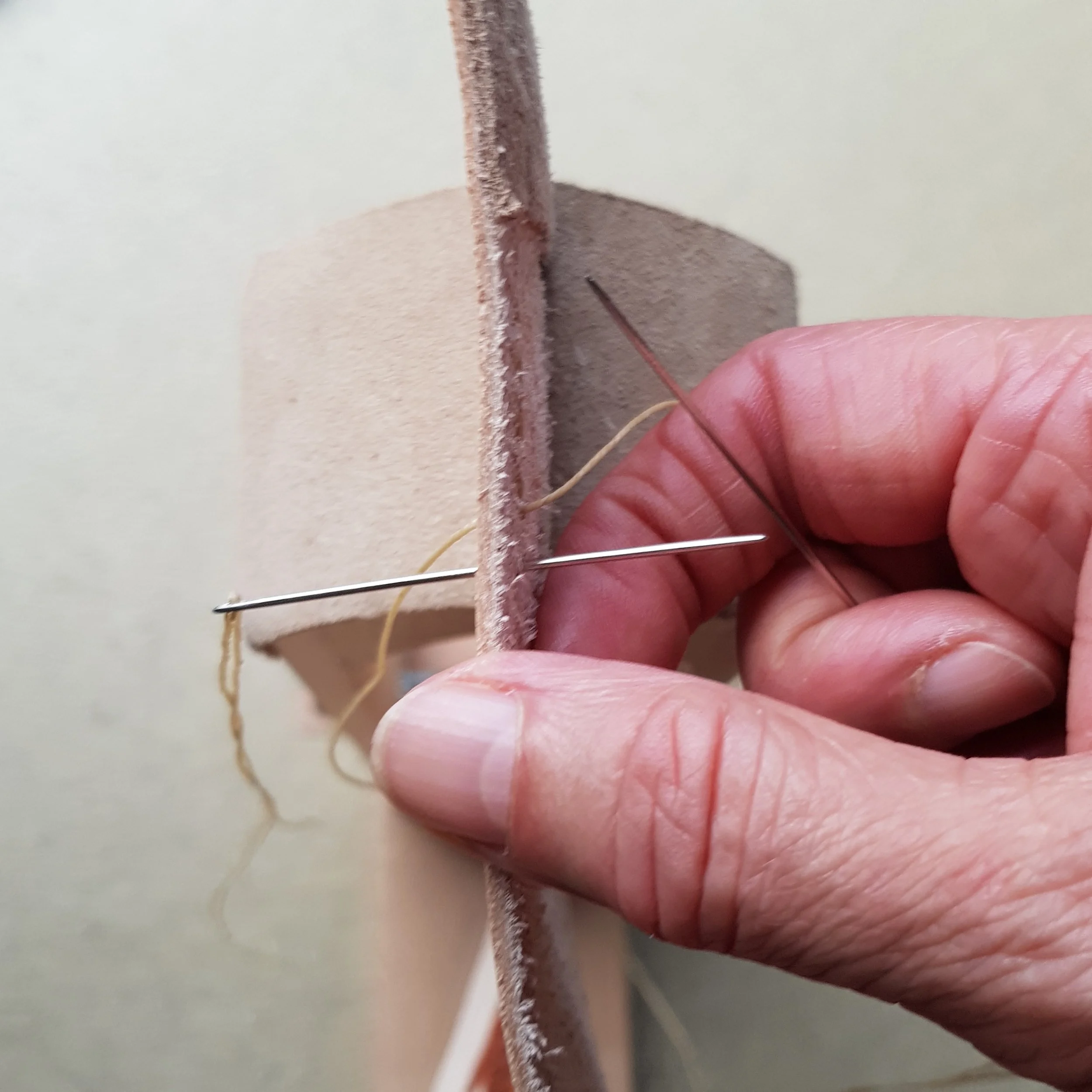 Using a stitching pony to aid stitching of a wristband to its lining.