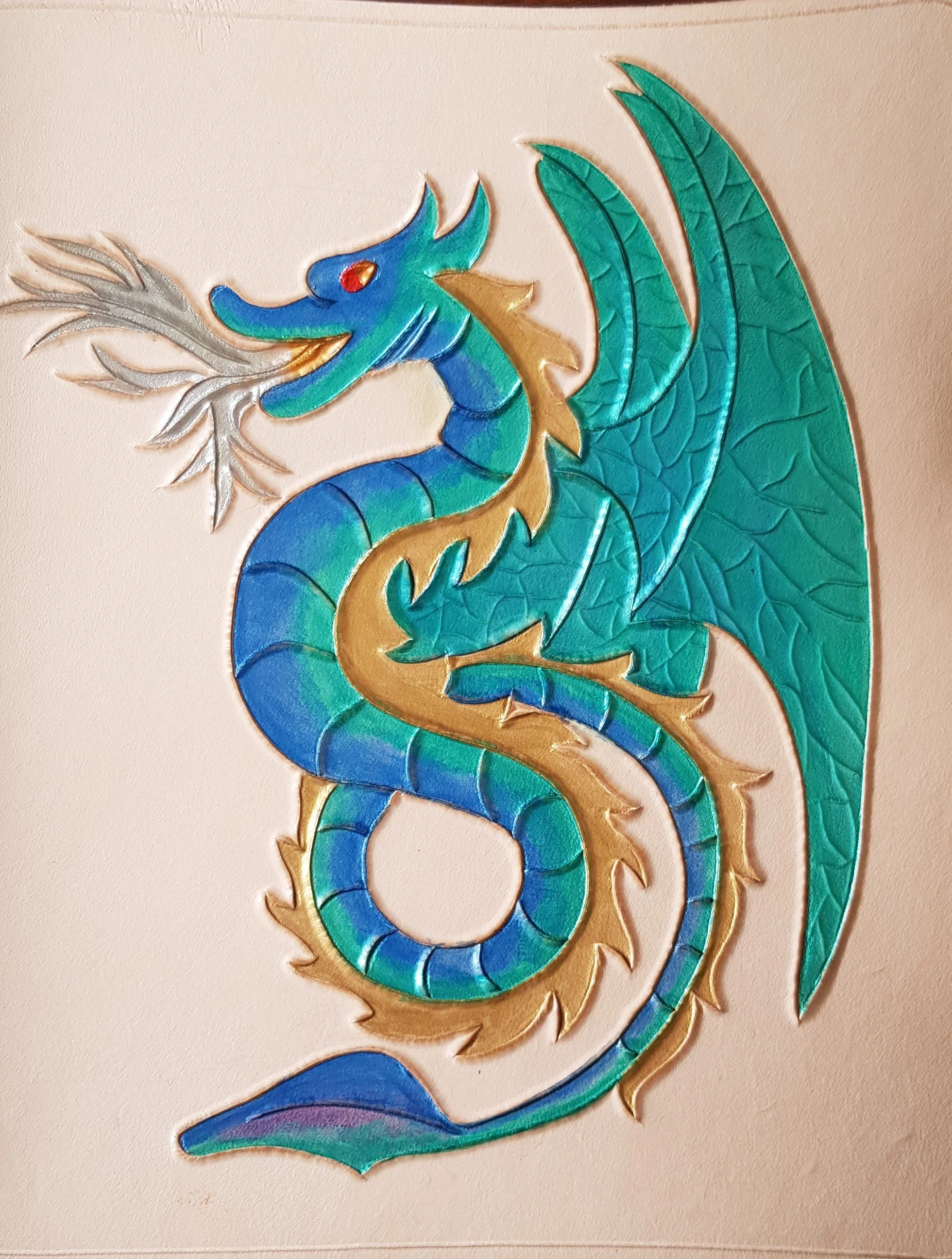Sea Serpent.jpg Winged sea serpent in metallic silver, blue and green, breathing silver-gold flames. Full grain vegetable tanned leather. Refillable; contains notebook