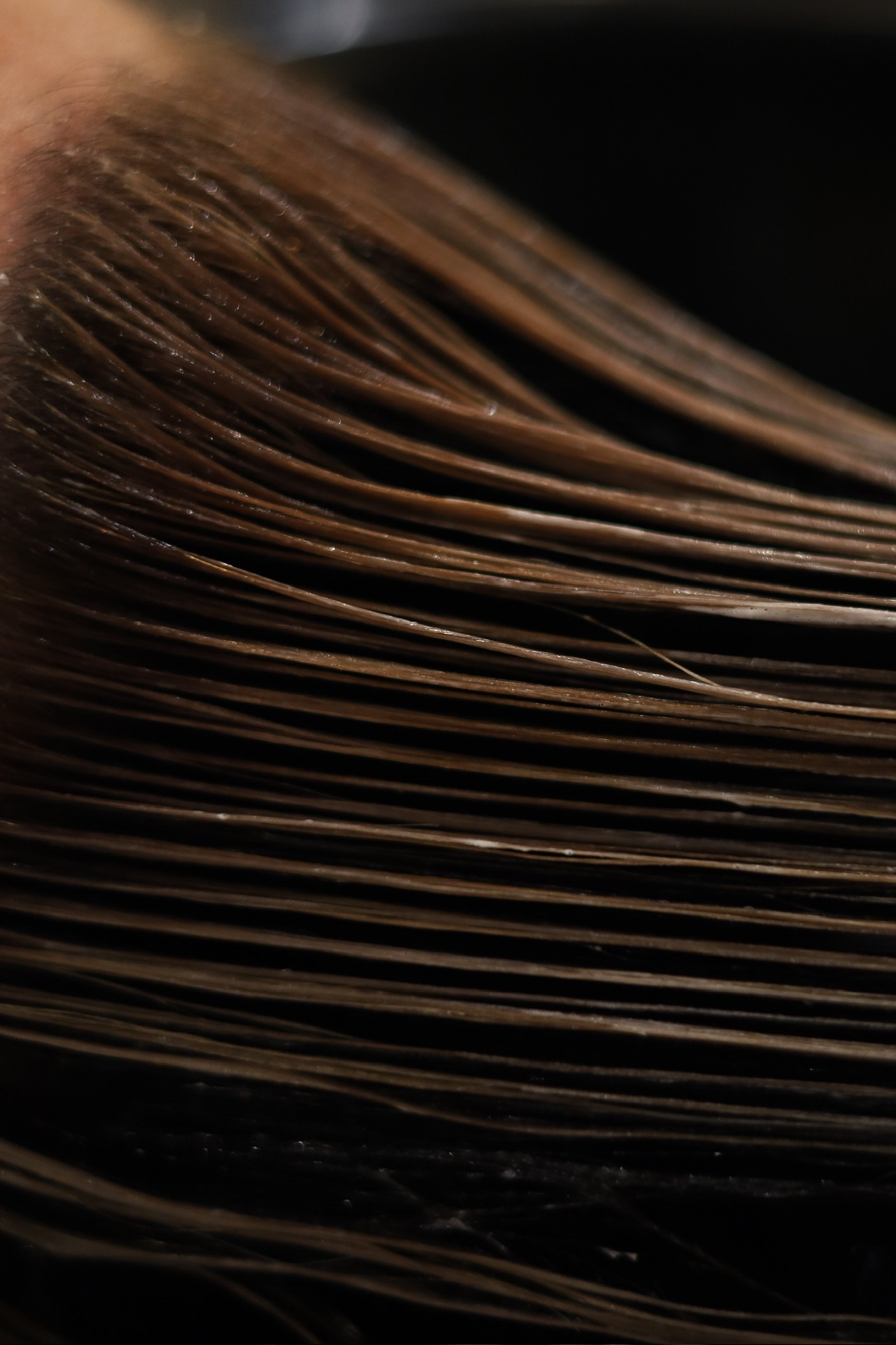 Hair is being washed at a salon sink with shampoo lathered in it.