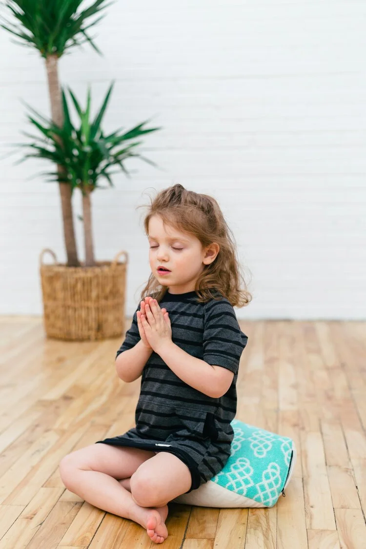Jeune fillette priant sur le sol