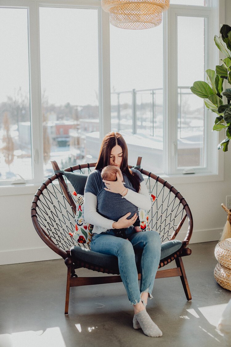 Jeune maman avec bébé emmailloté