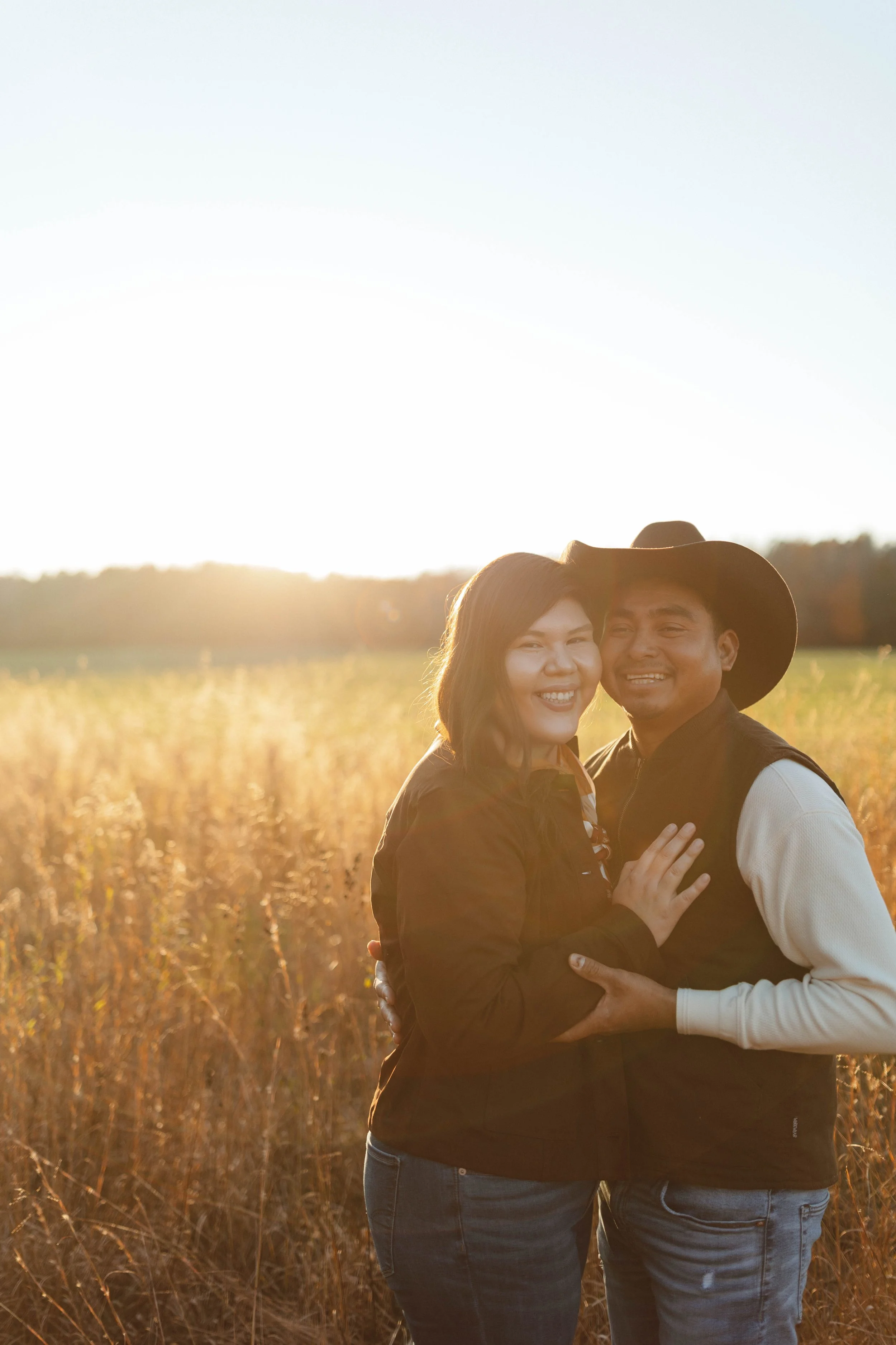 couple stands embracing one another in golden field
