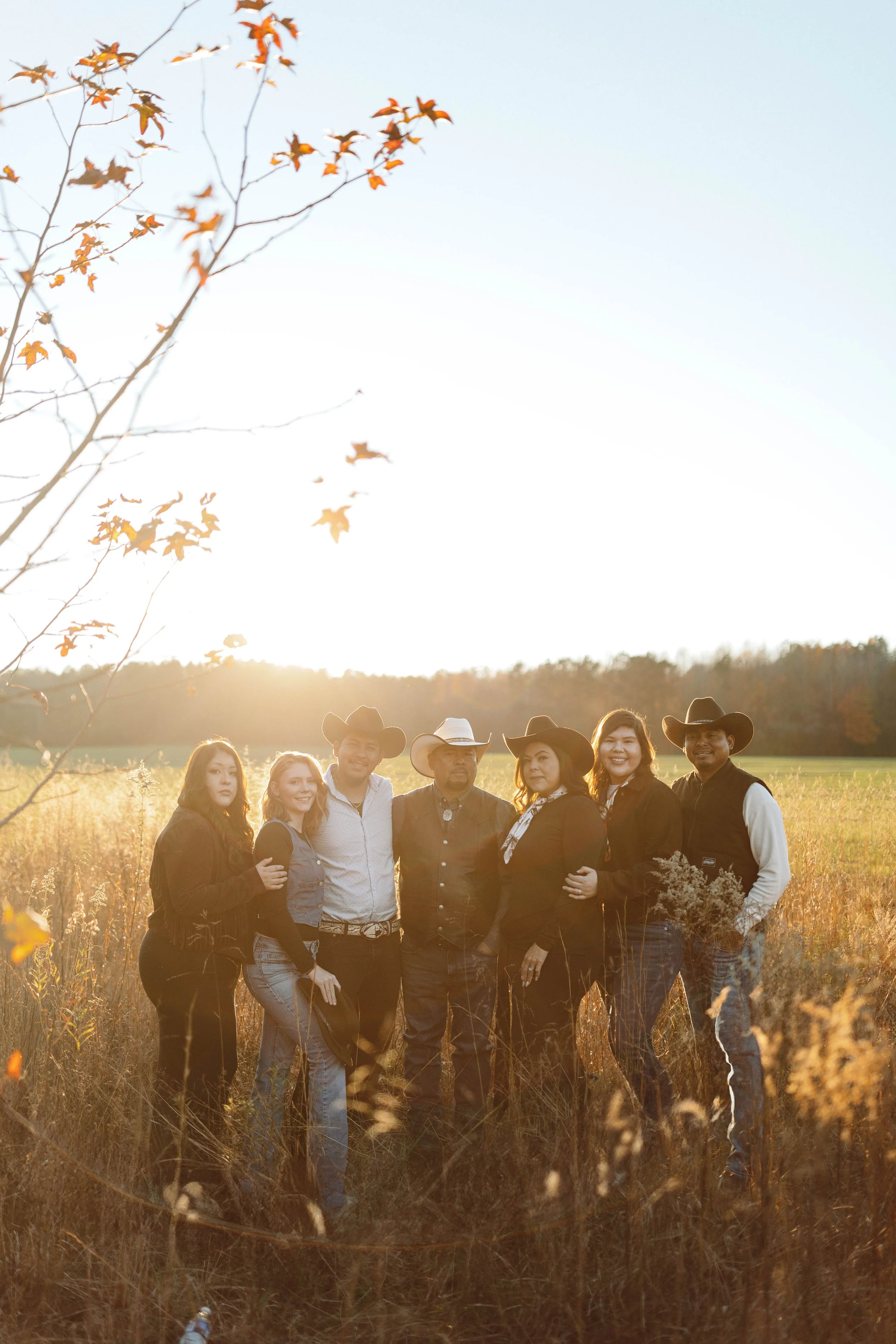 family stands in field surrounded by golden sunlight in Suffolk VA