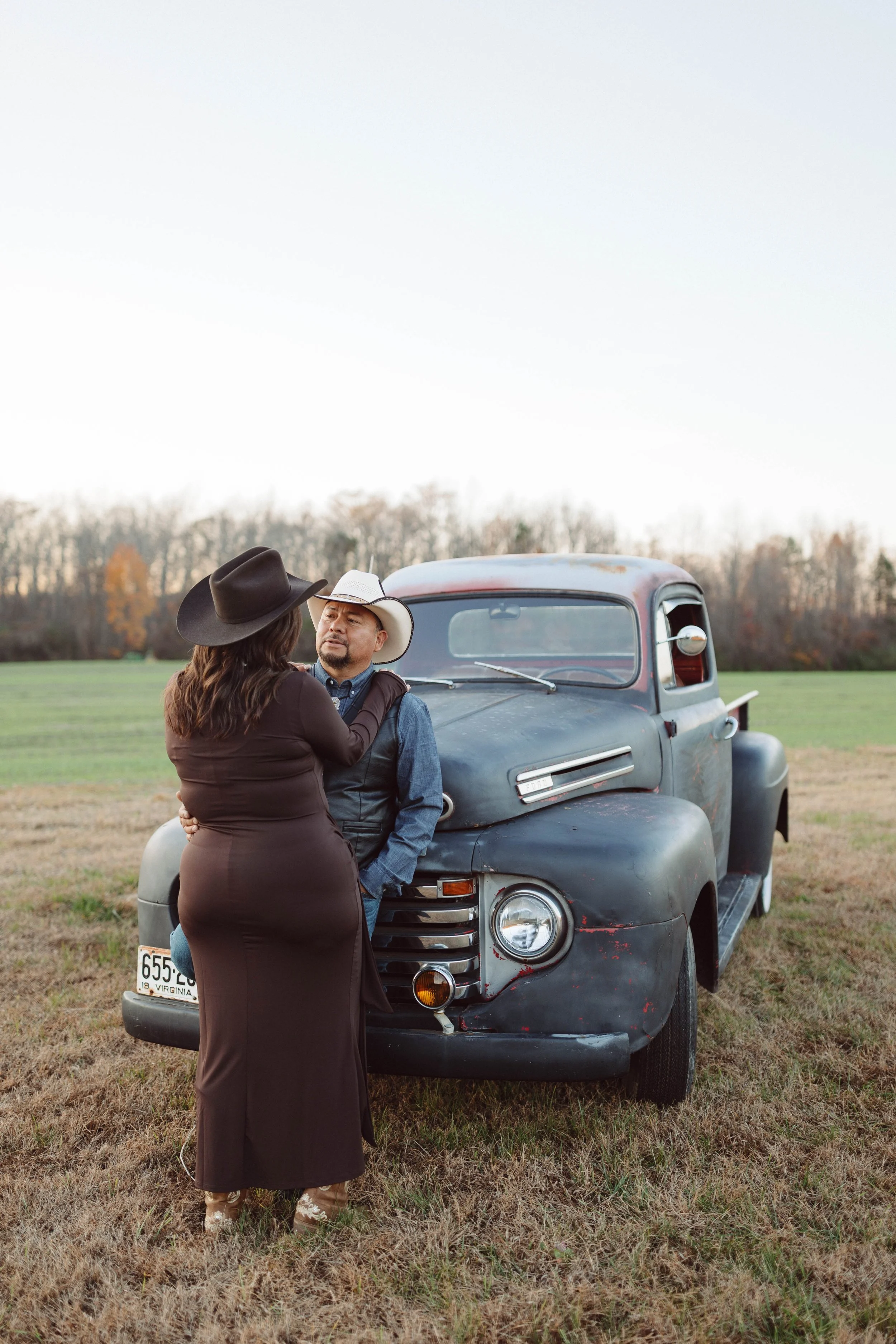 couple embraces while leaning against an antique ford pickup truck