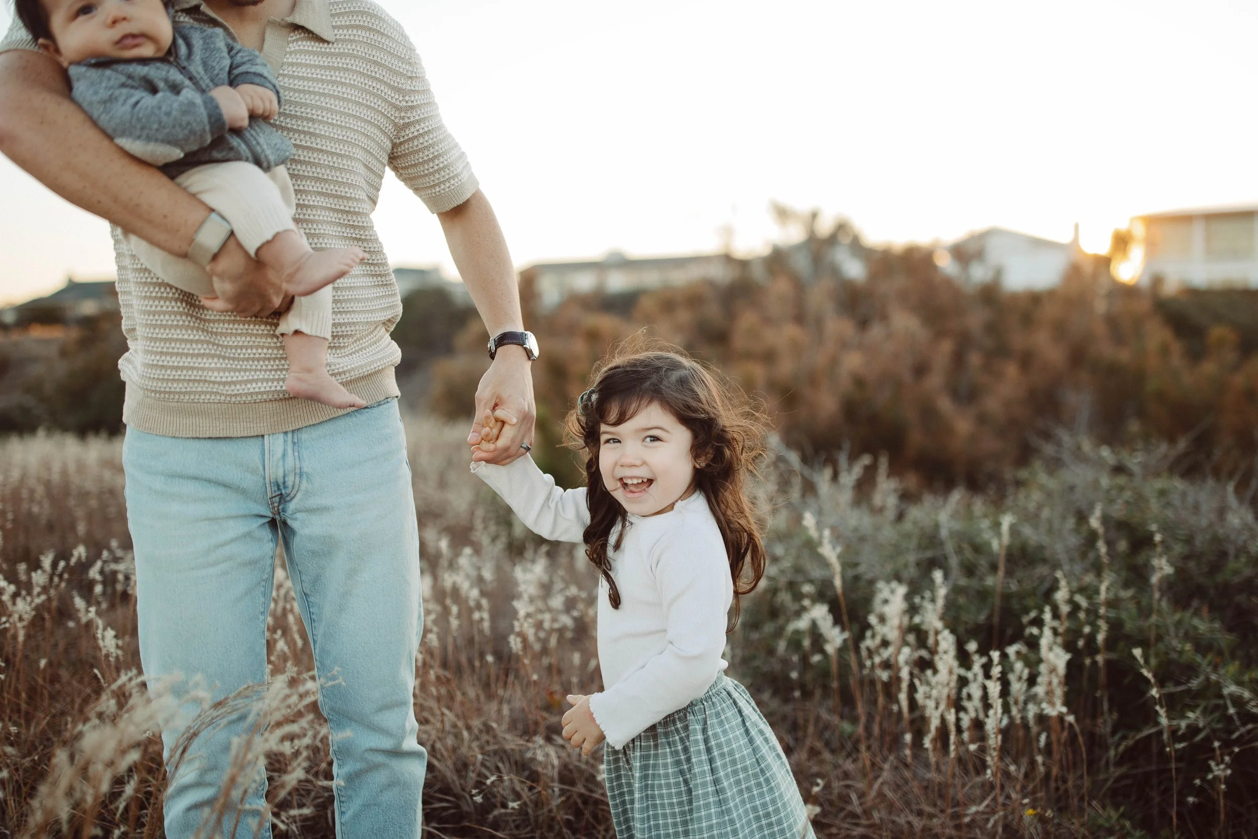 Dad holding his two kids during a family session at the Virginia Beach oceanfront