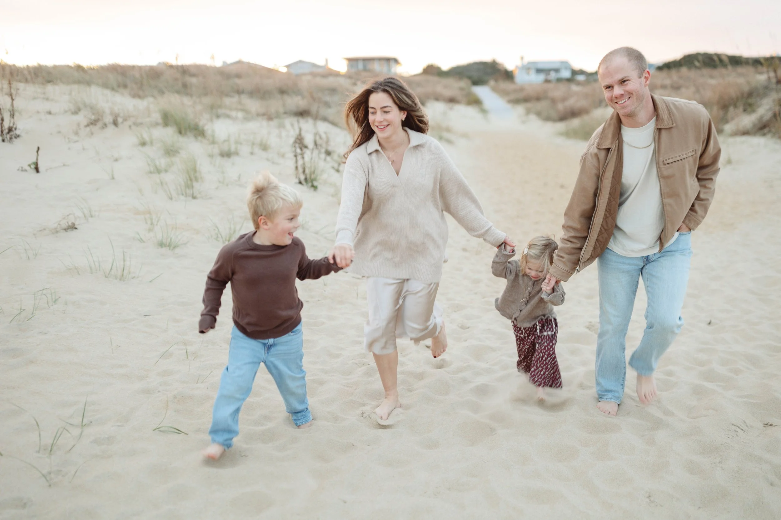 Family of four running on the beach in Virginia Beach