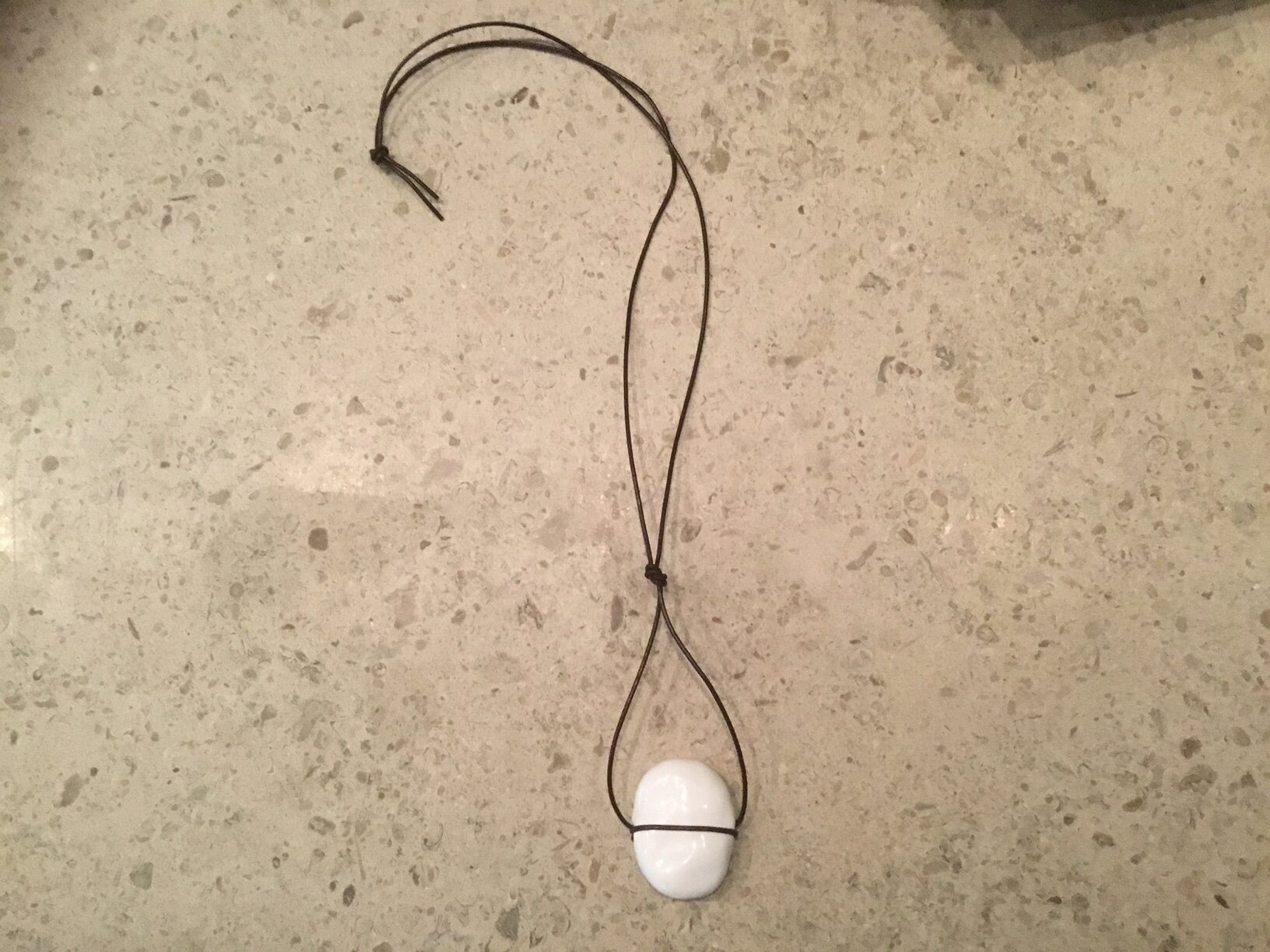 White Flat Oval Bead on Brown Leather