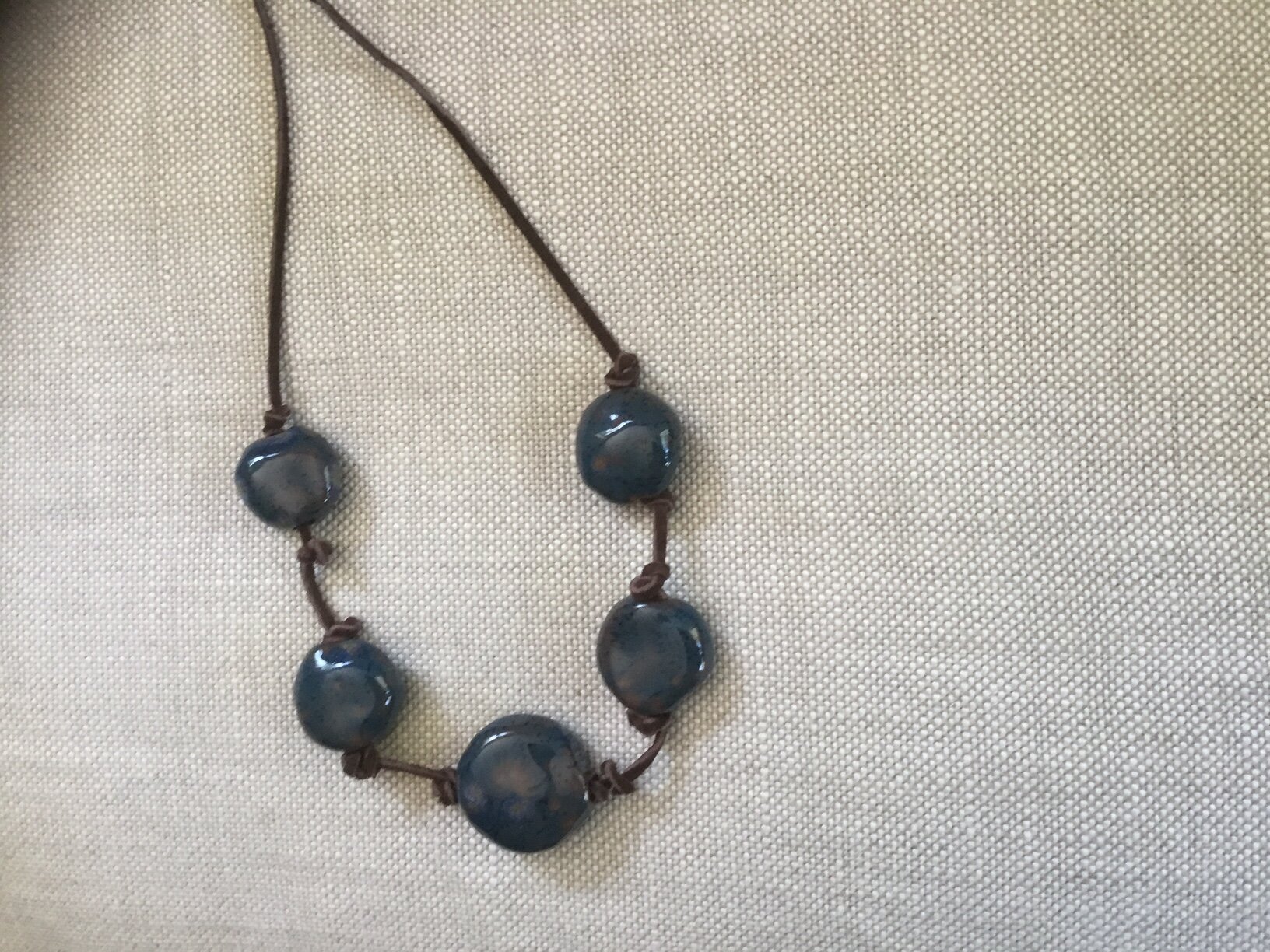 Tourquoise Flat Round Beads on Brown Suede