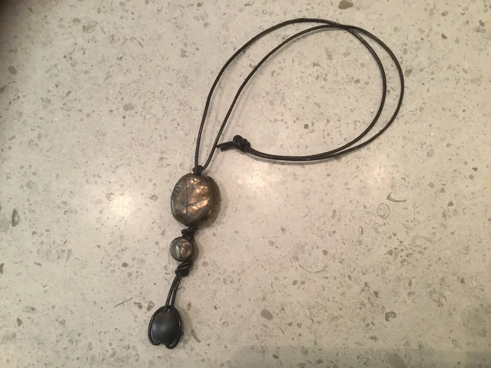 1 large 2 small bronze beads on brown leather.JPG