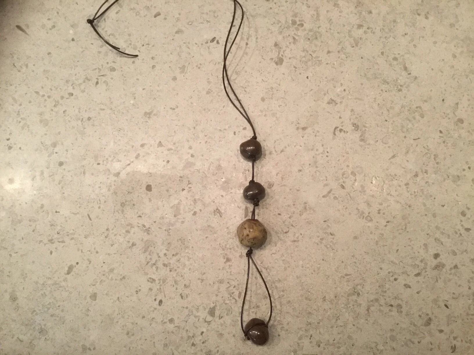 3 small brown, 1 med tan on thin brown leather.JPG