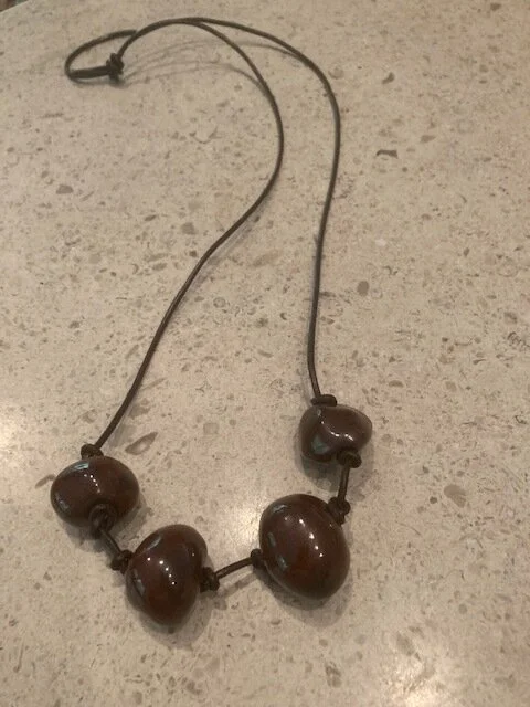 4 Iron Ore beads on brown leather.jpg