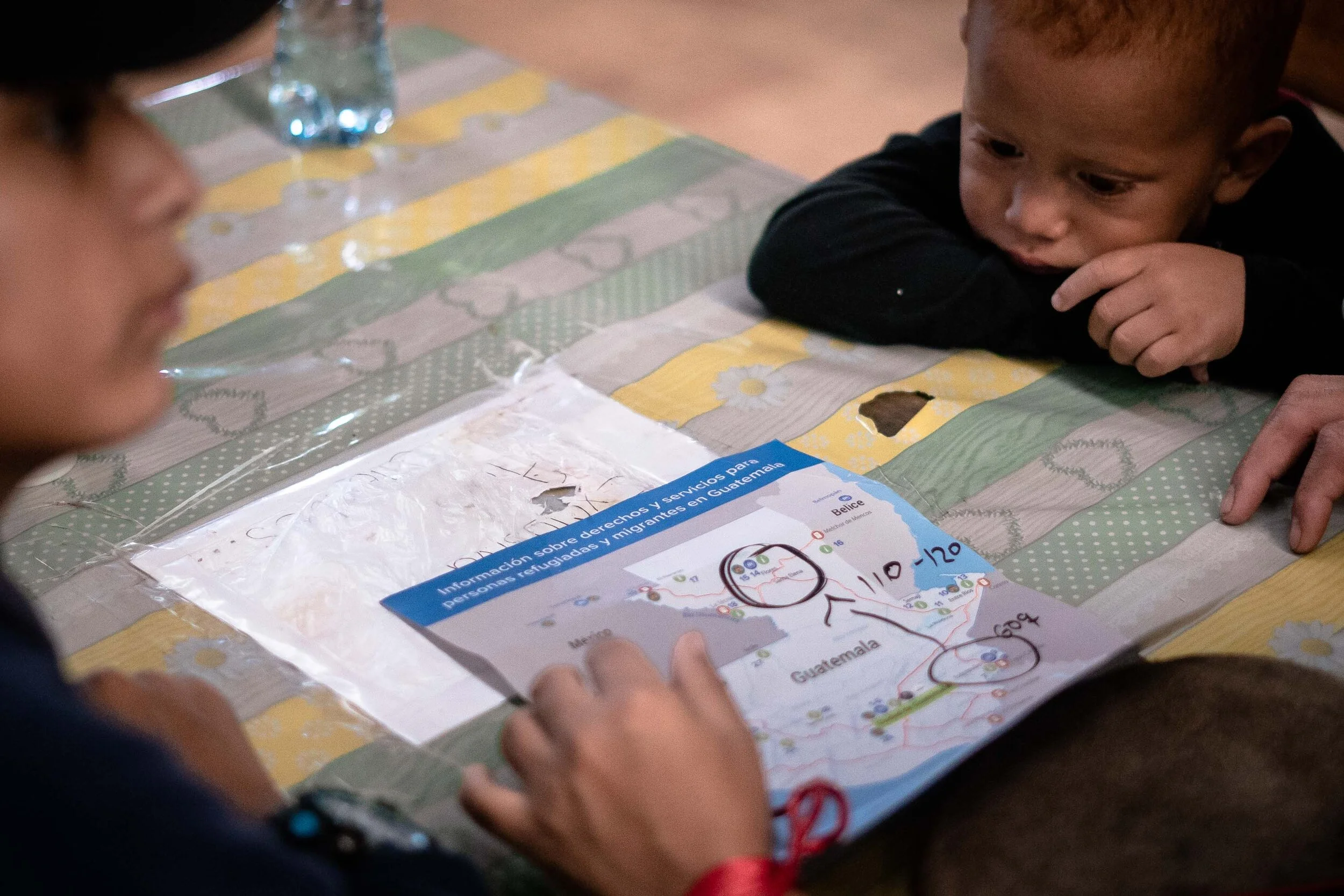  Members of a migrant caravan consult a sparsely detailed UN-issued map as they make their way northward through Guatemala.   January, 2020 