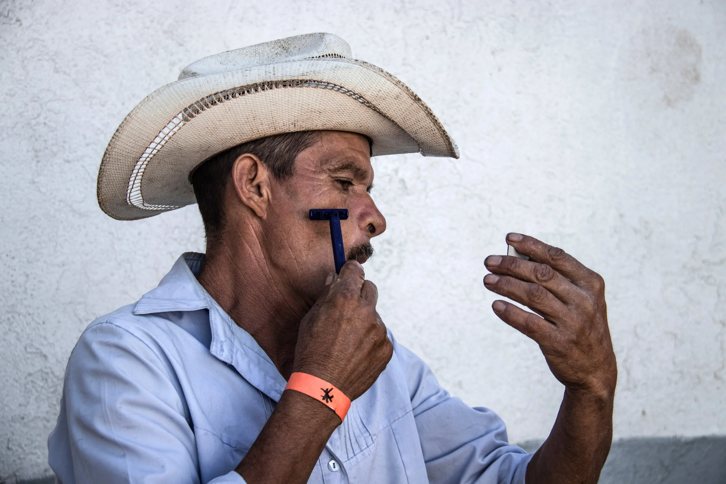  Jose Maria, 42, shaves with the help of a broken mirror in a migrant shelter in Tijuana.   November, 2018 