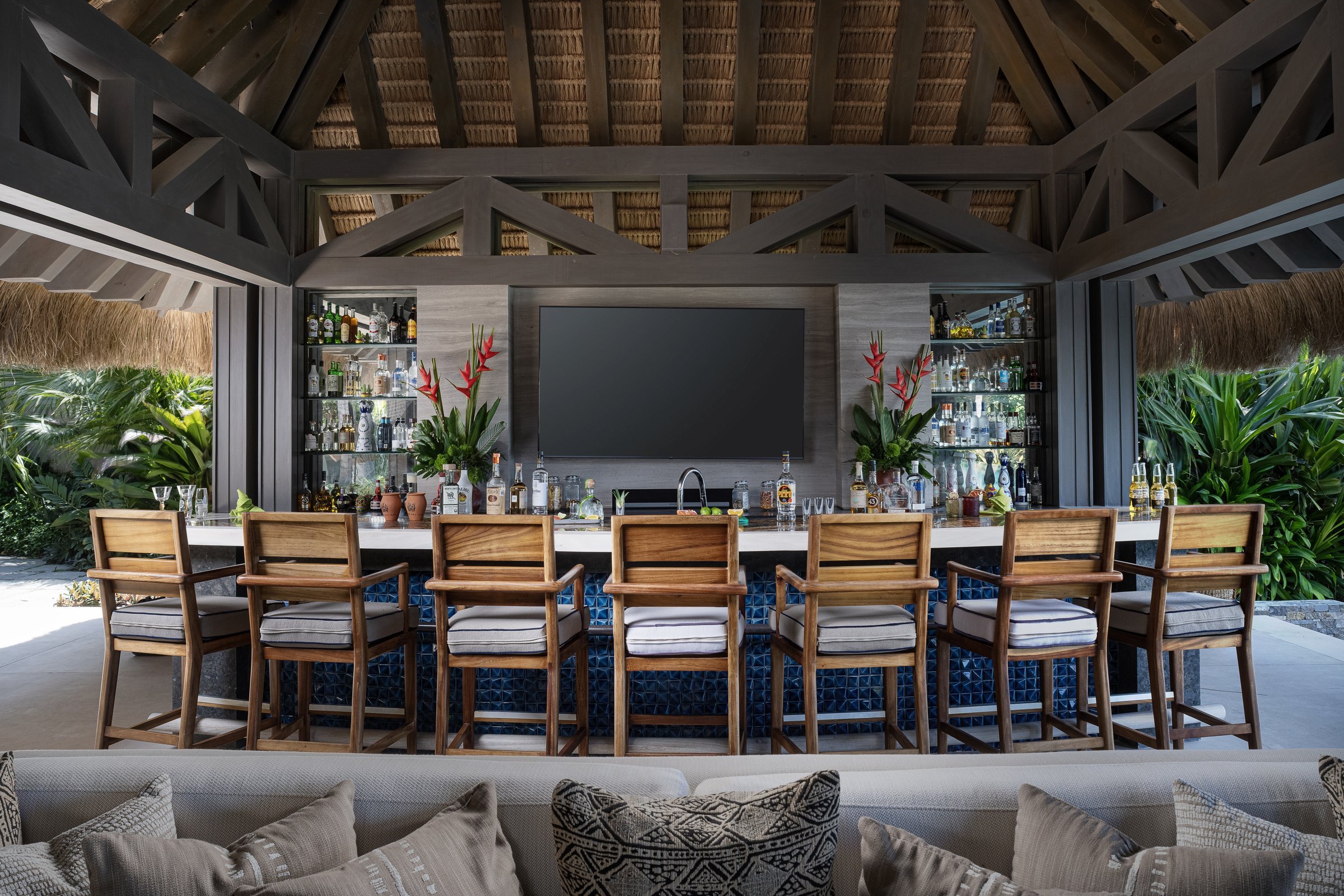 The palapa bar, stools lined beneath the thatch