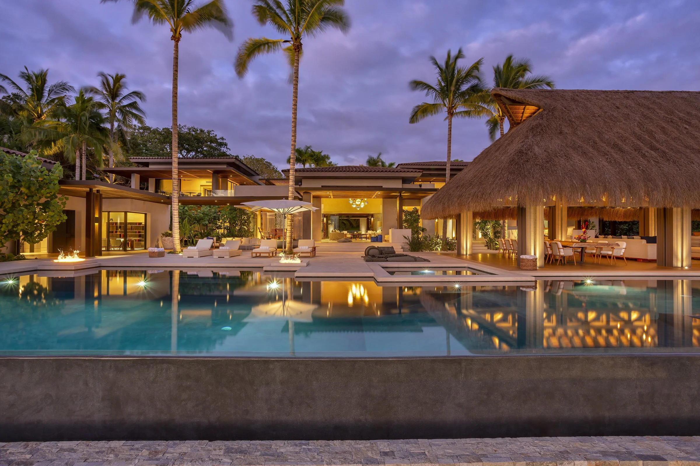 Casa del Oso at twilight — the pool, palapa and residence aglow