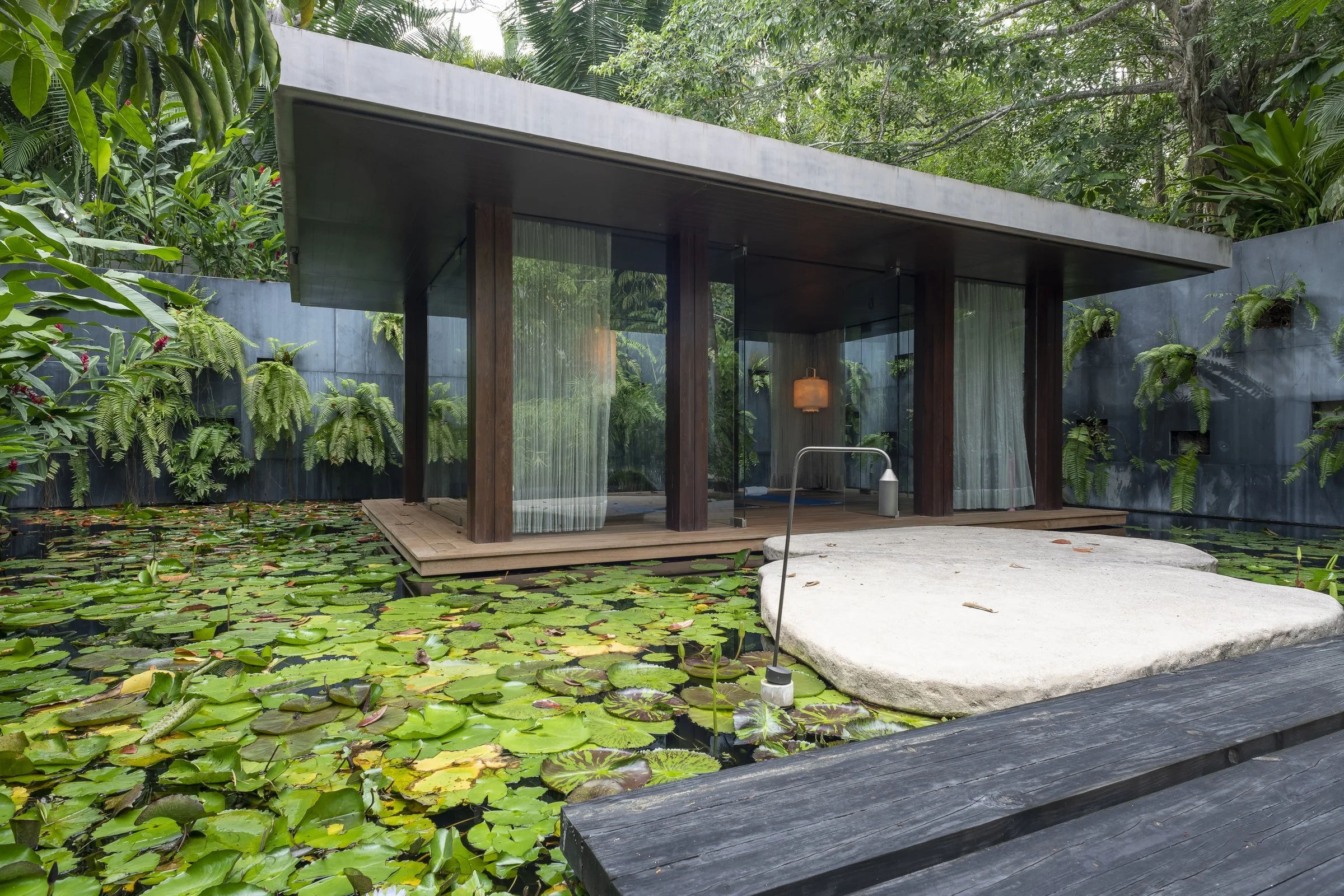 The glass meditation pavilion floating on its lily pond