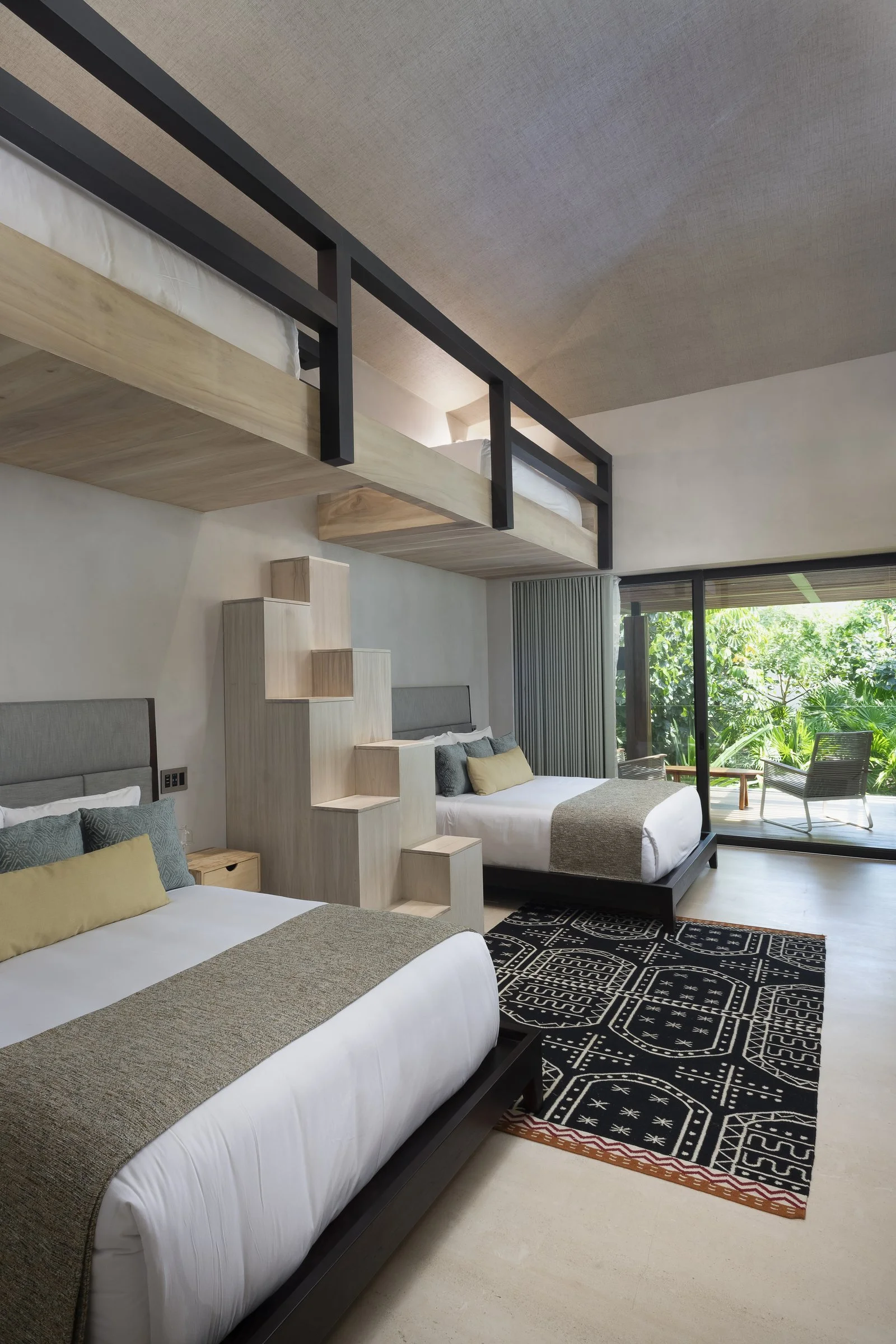A Bunk room with twin-over-queen bunks and stair access