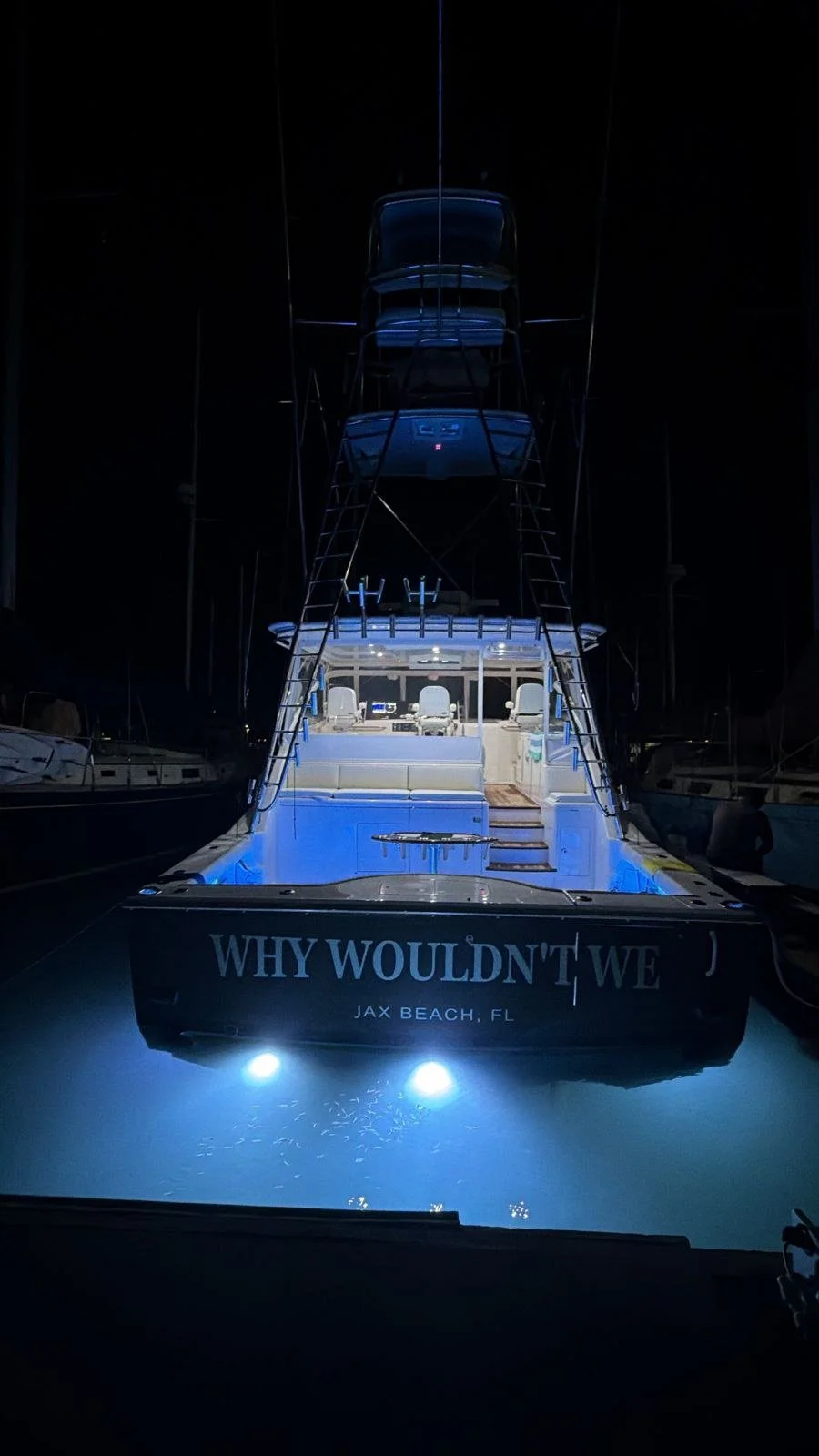The stern at night, underwater lights glowing