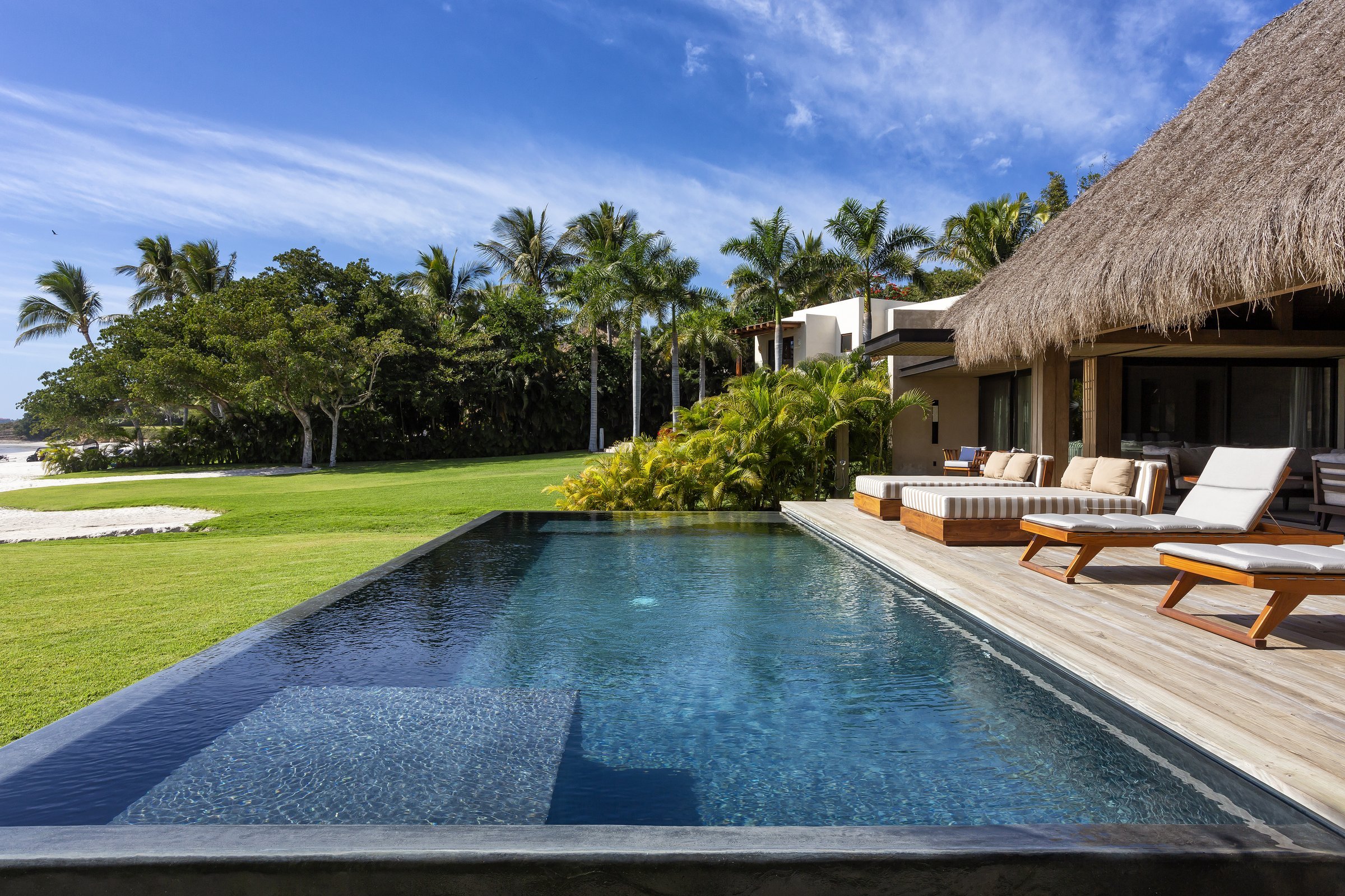 The beach cabana's infinity pool, its edge dissolving toward the sand