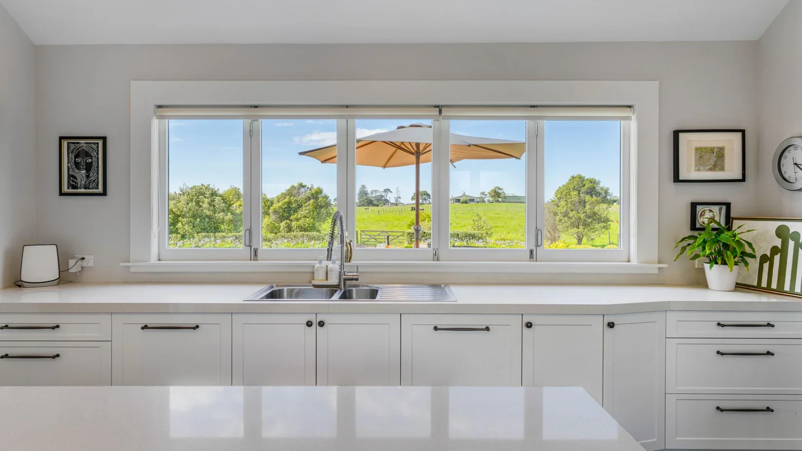 Custom timber kitchen windows overlooking rural Clarkes Beach, part of the full heritage joinery package supplied for the 111 Wharf Road villa restoration.