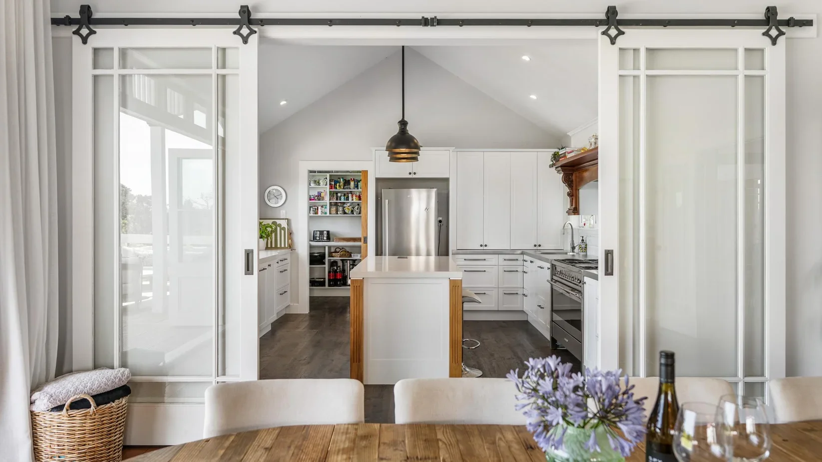 Custom traditional sliding timber doors leading into the kitchen of the restored heritage villa at 111 Wharf Road.