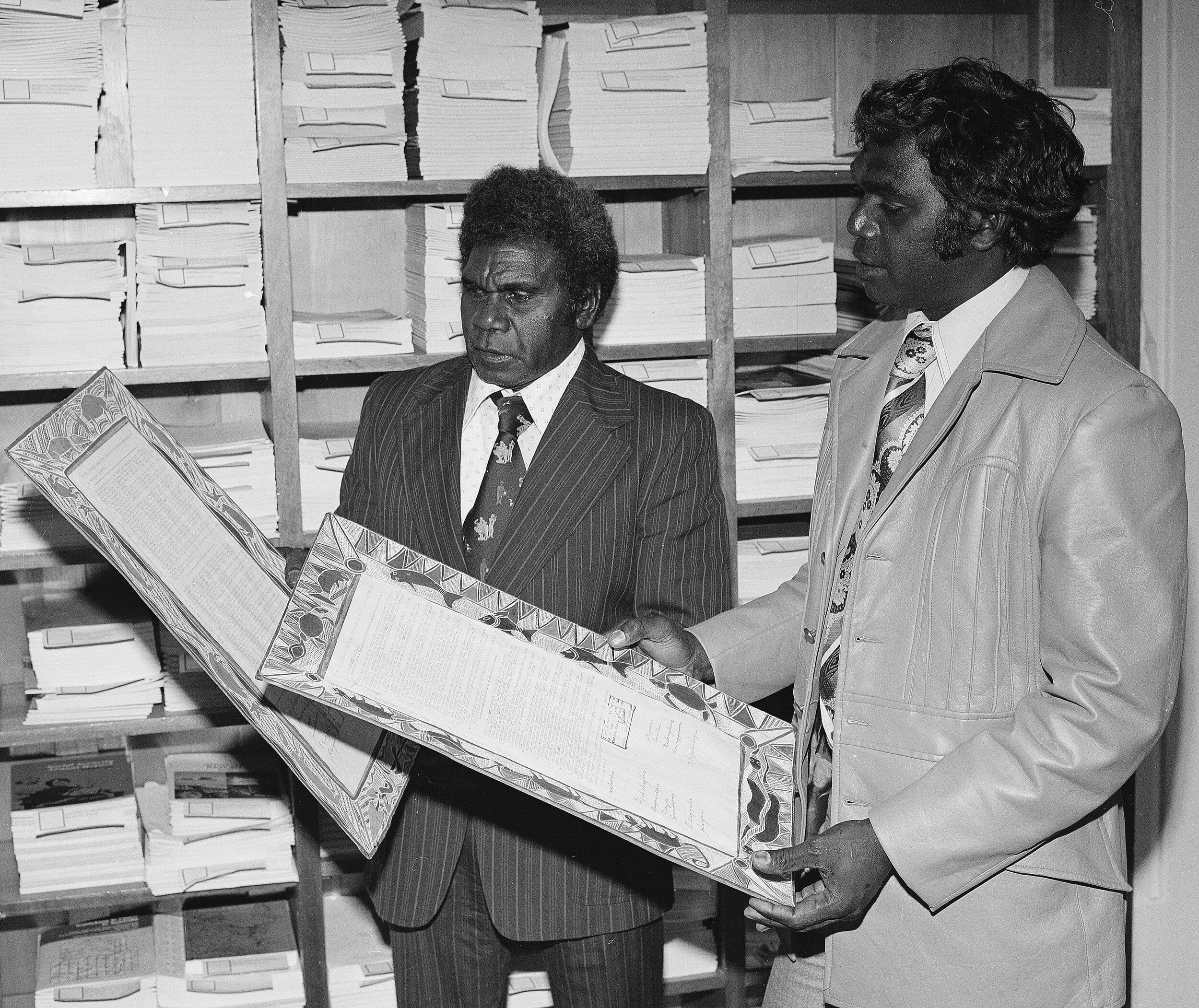 Silas Roberts (left), then Chairman of the Northern Land Council, and Galarrwuy Yunupingu (right), then manager of the Northern Land Council with the Yirrkala Bark Petitions, 1963, in Parliament House   Courtesy of AIATSIS, Yirrkala community and the House of Representatives, Australian Parliament, item AIAS.031.BW-N00254_03