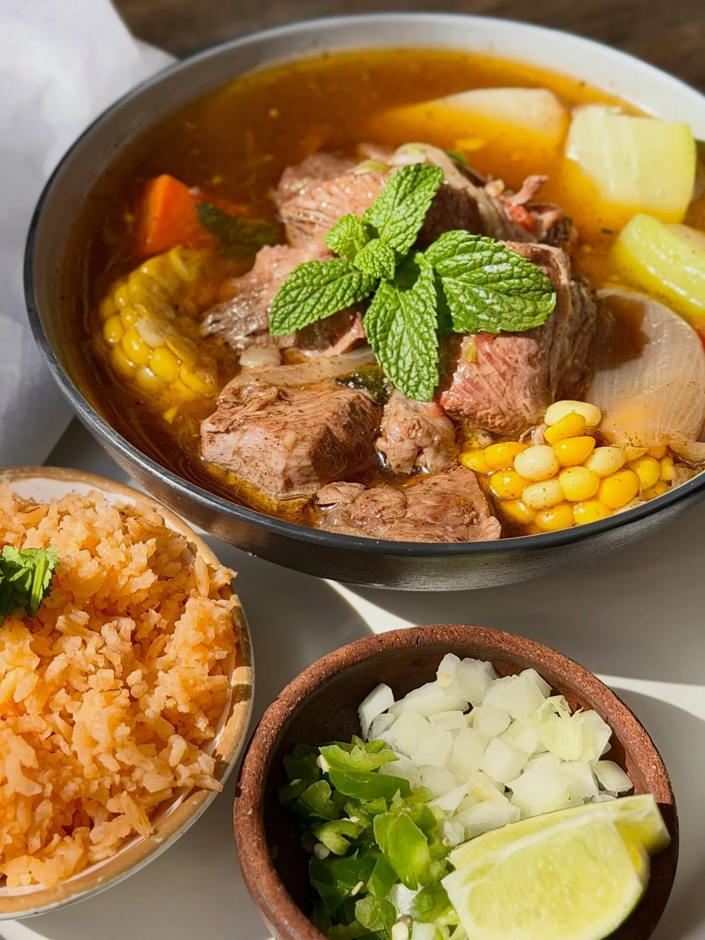 It&rsquo;s 70 degrees outside and sounds like caldito weather to us. 🌞🍋&zwj;🟩Tender beef slow-cooked with chayote, zucchini, carrots, elote, and potatoes + served with arroz mexicano, corn tortillas, serrano chile, onion, and fresh lime. 🥄

Ven a