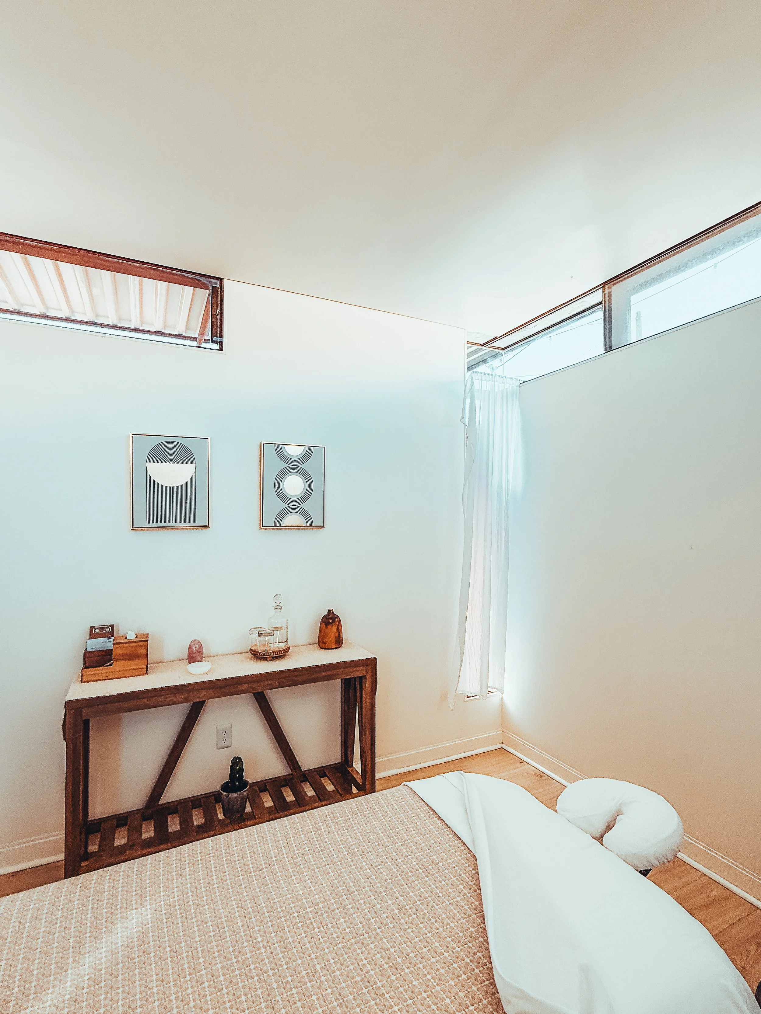 A plate with avocado toast topped with cherry tomatoes, a bowl of mixed berries, two small pancakes, a cup of black coffee, and a book titled 'The Villa' by Rachel Hawkins, all placed on a striped towel next to a swimming pool.