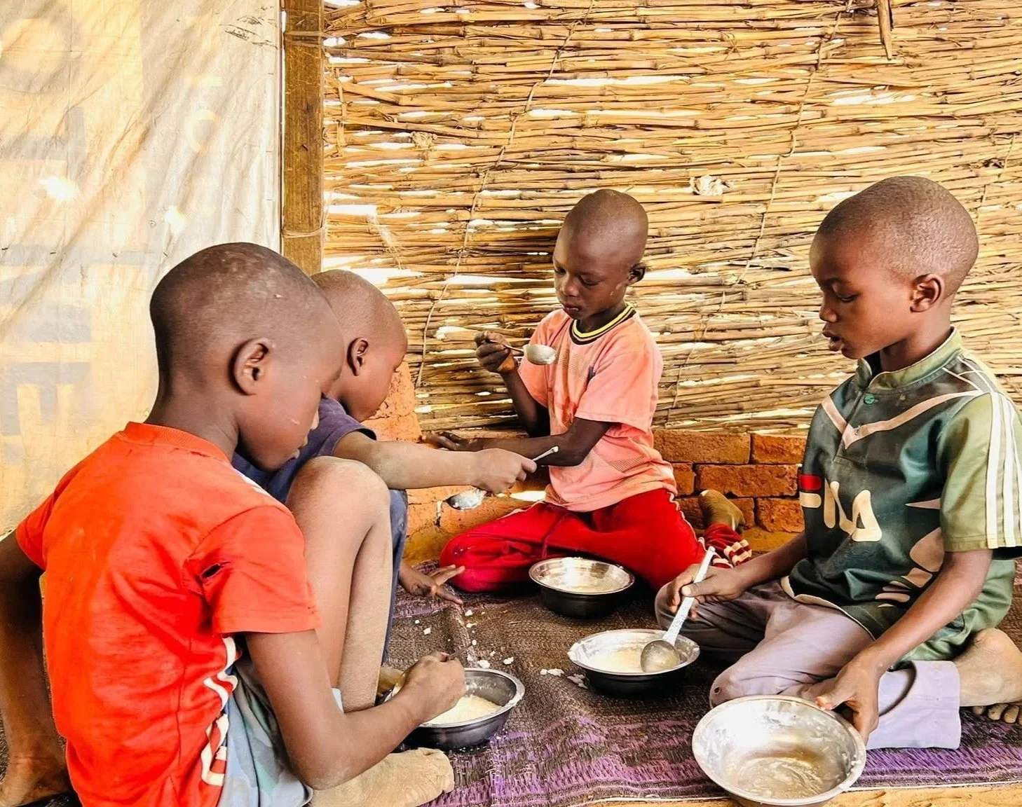 A healthcare worker feeds refugee children